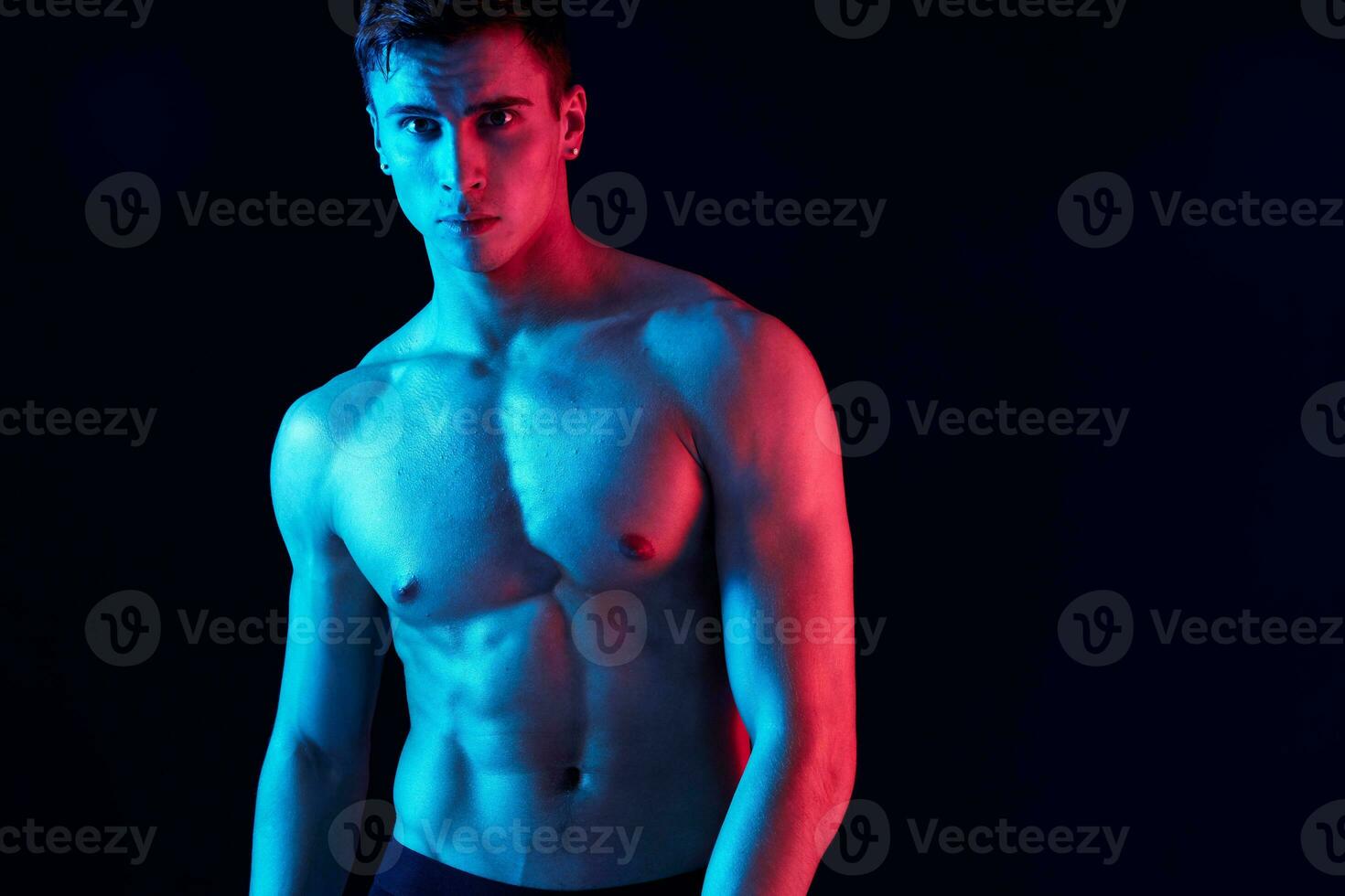 portrait of an attractive guy with a pumped-up torso bodybuilder black background cropped view photo