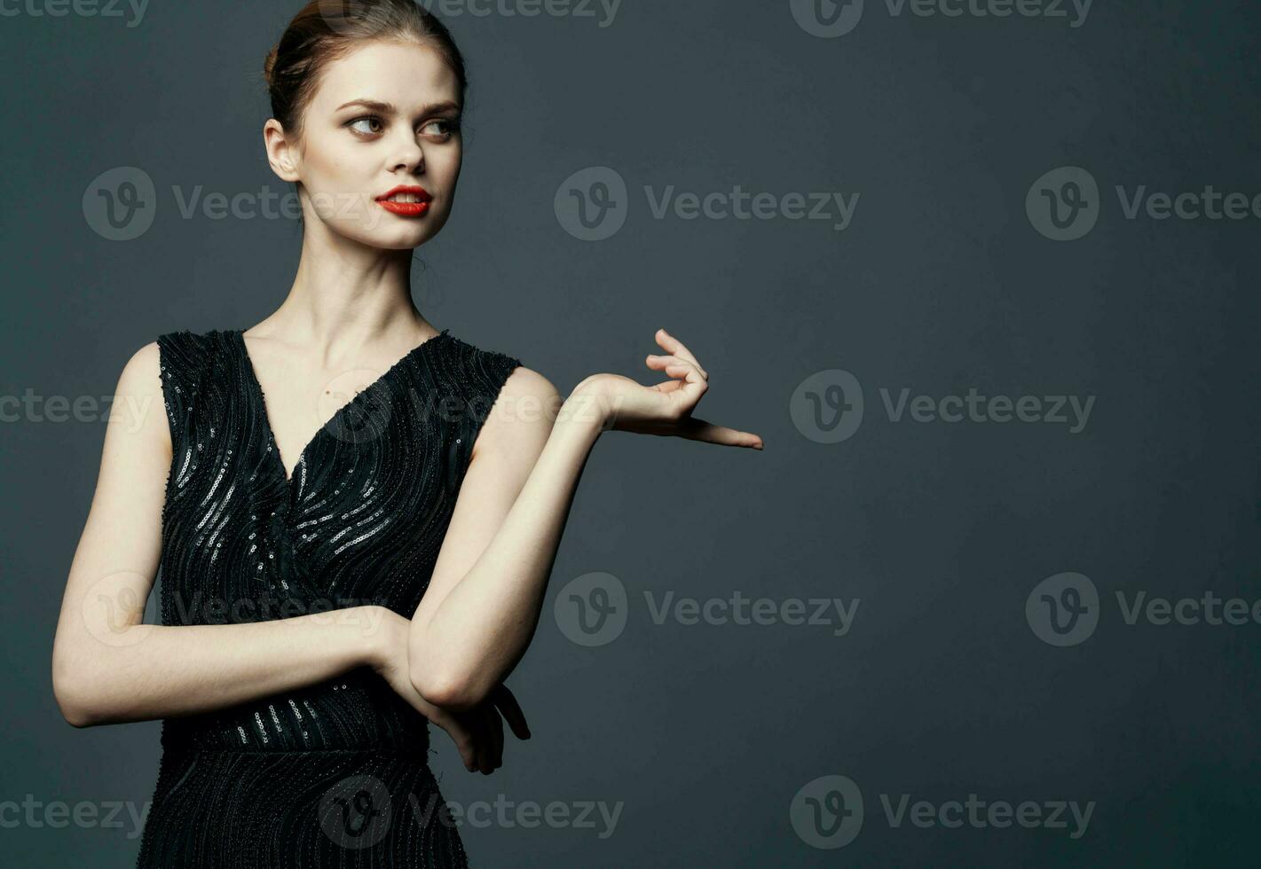 Woman shows her hands to the side on a gray background emotions advertising model photo