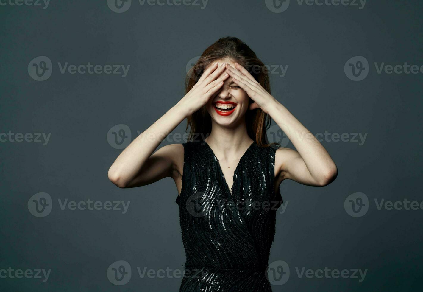 emocional mujer toques su cabeza con manos y negro vestir modelo gris antecedentes foto