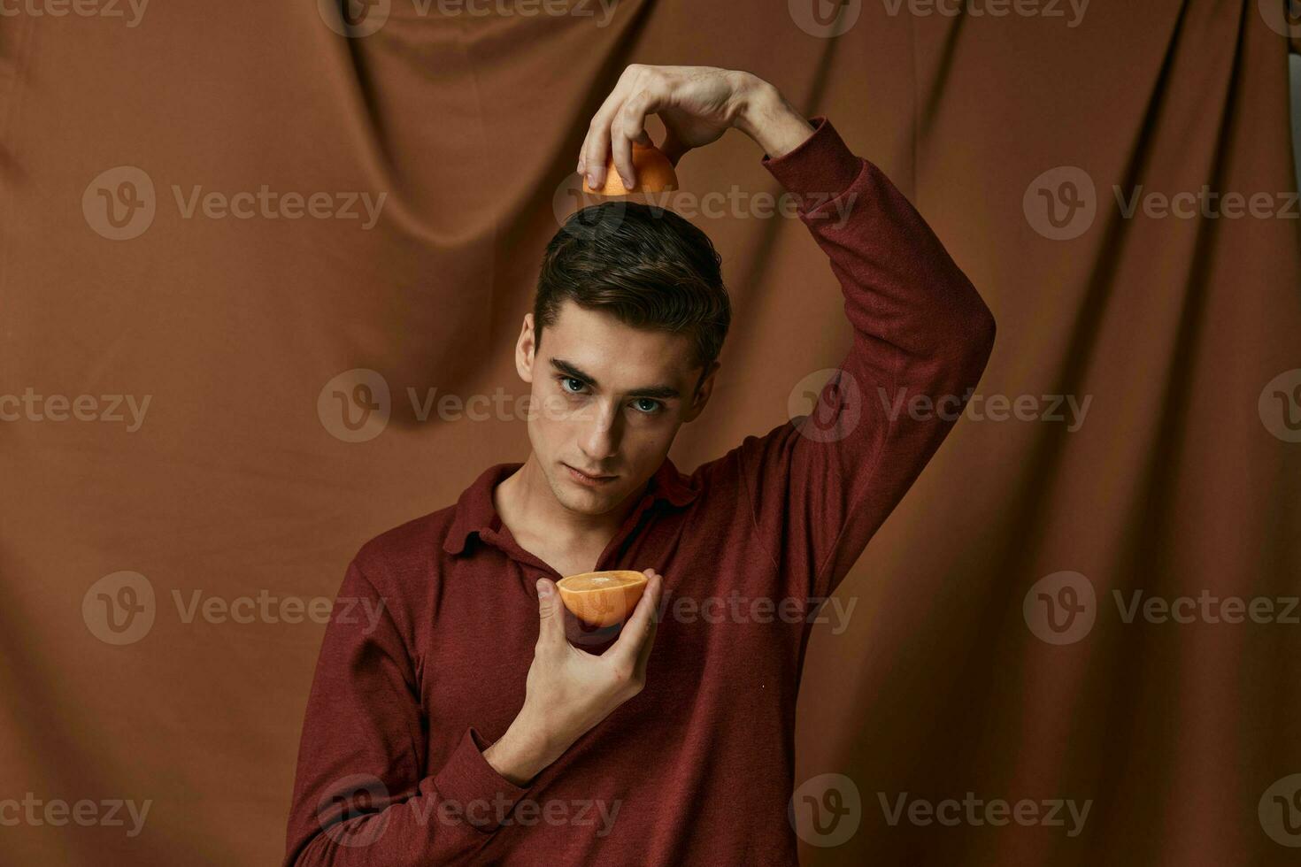man with oranges in hands on fabric background studio model photo
