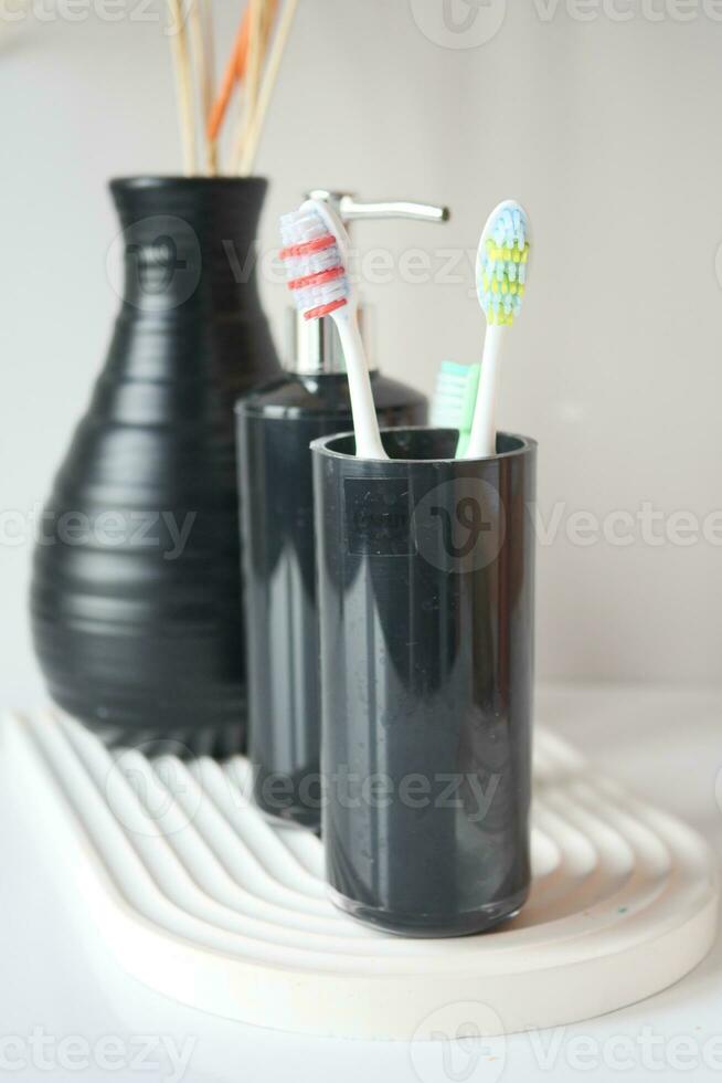cepillos de dientes en vidrio sobre mesa foto