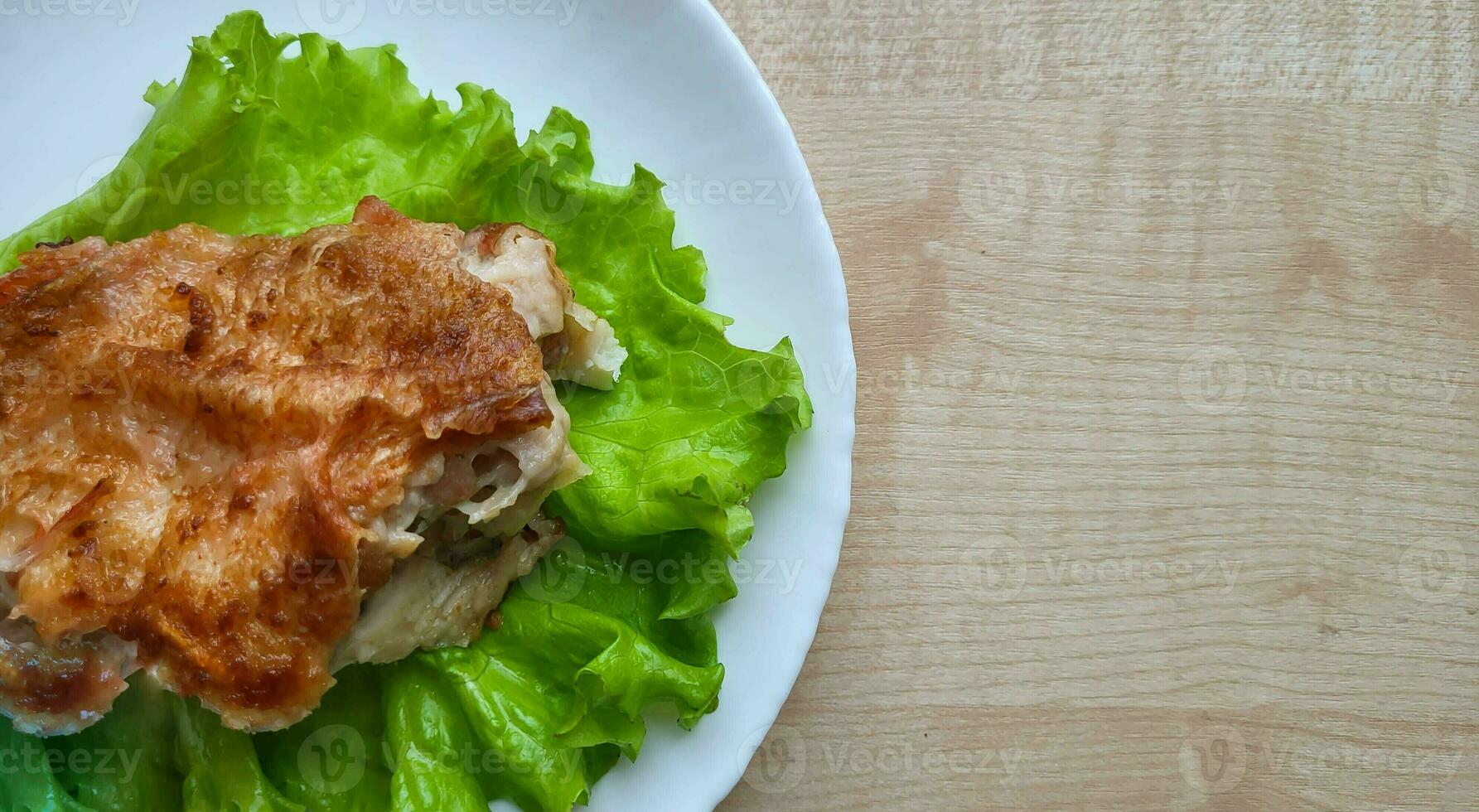 delicioso frito pescado mar bajo en un blanco plato en un de madera mesa, horizontal ver desde encima foto