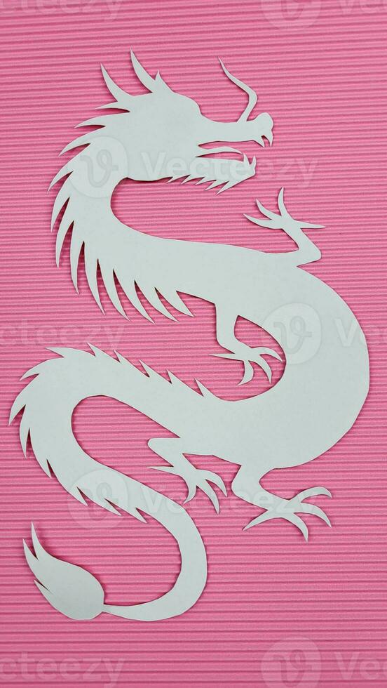 Paper white dragon on pink corrugated paper background. The concept of the new year. photo
