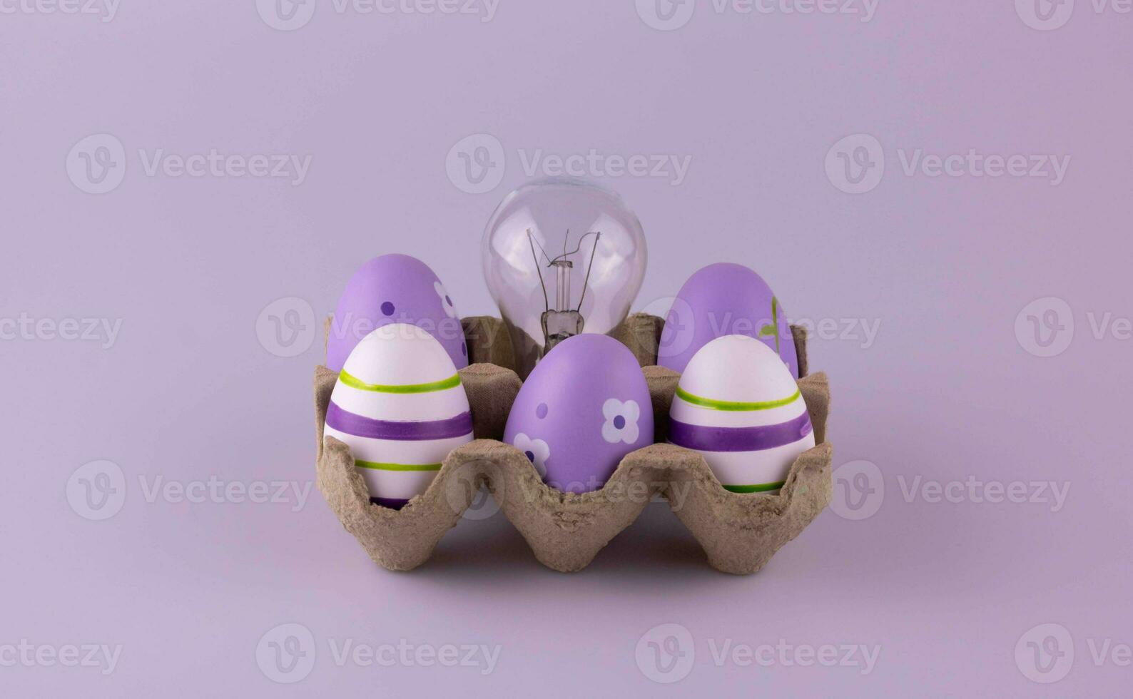 The cardboard egg container contains lilac Easter eggs and a tungsten