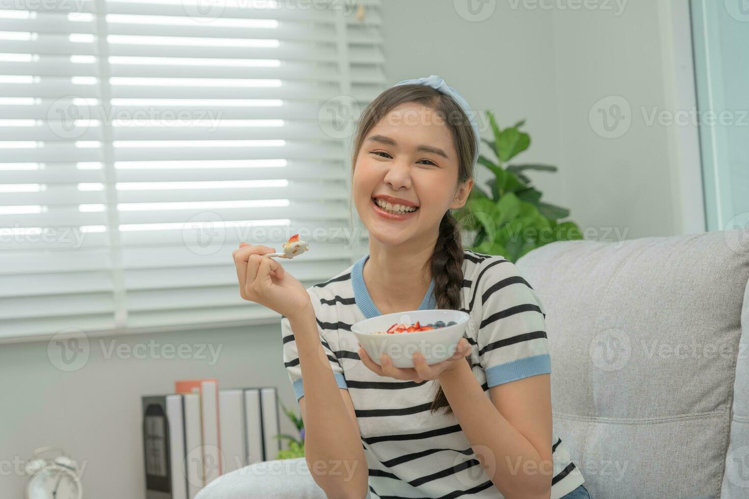 sano alimento. hermosa hembra niña disfrutar comer yogur, Granola, Fresco frutas en desayuno salud en casa. contento joven mujer sonrisa en Mañana bueno emoción. haciendo dieta, desintoxicación, dieta, limpiar comer, vegetariano foto