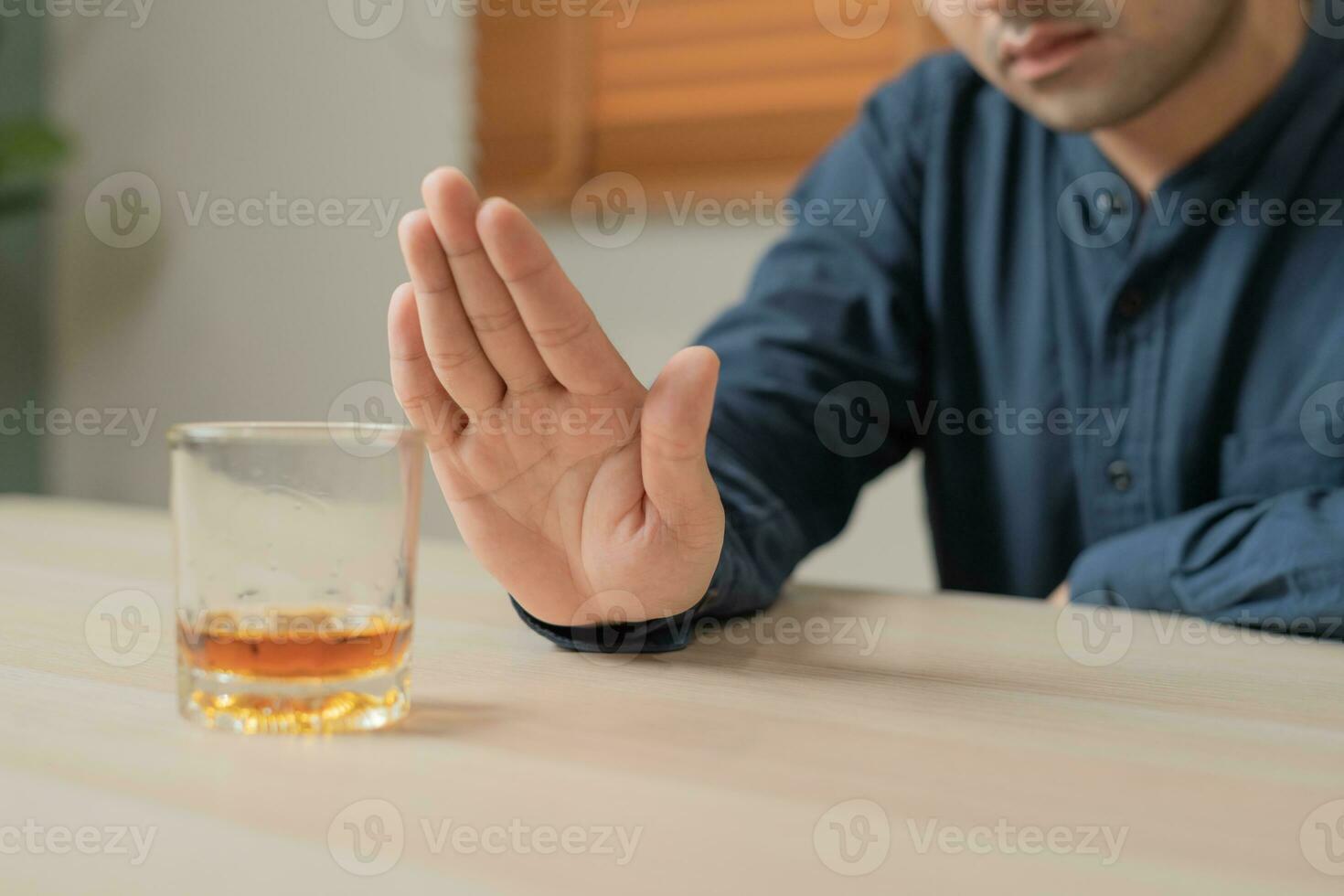 man refuses say no and avoid to drink an alcohol whiskey , stopping hand sign male, alcoholism treatment, alcohol addiction, quit booze, Stop Drinking Alcohol. Refuse Glass liquor, unhealthy, reject photo