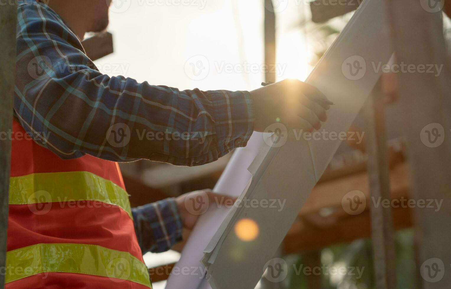inspector or engineer is inspecting construction and quality assurance new house using a blue print. Engineer or architects or contactor work to build the house before handing it over to the homeowner photo