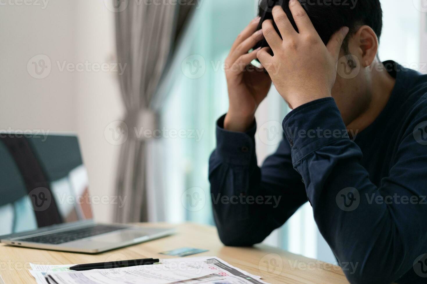Stressed and headache asian man with large bills or invoices no money to pay to expenses and credit card debt. shortage, Financial problems, mortgage, loan, bankruptcy, bankrupt, poor, empty wallet photo
