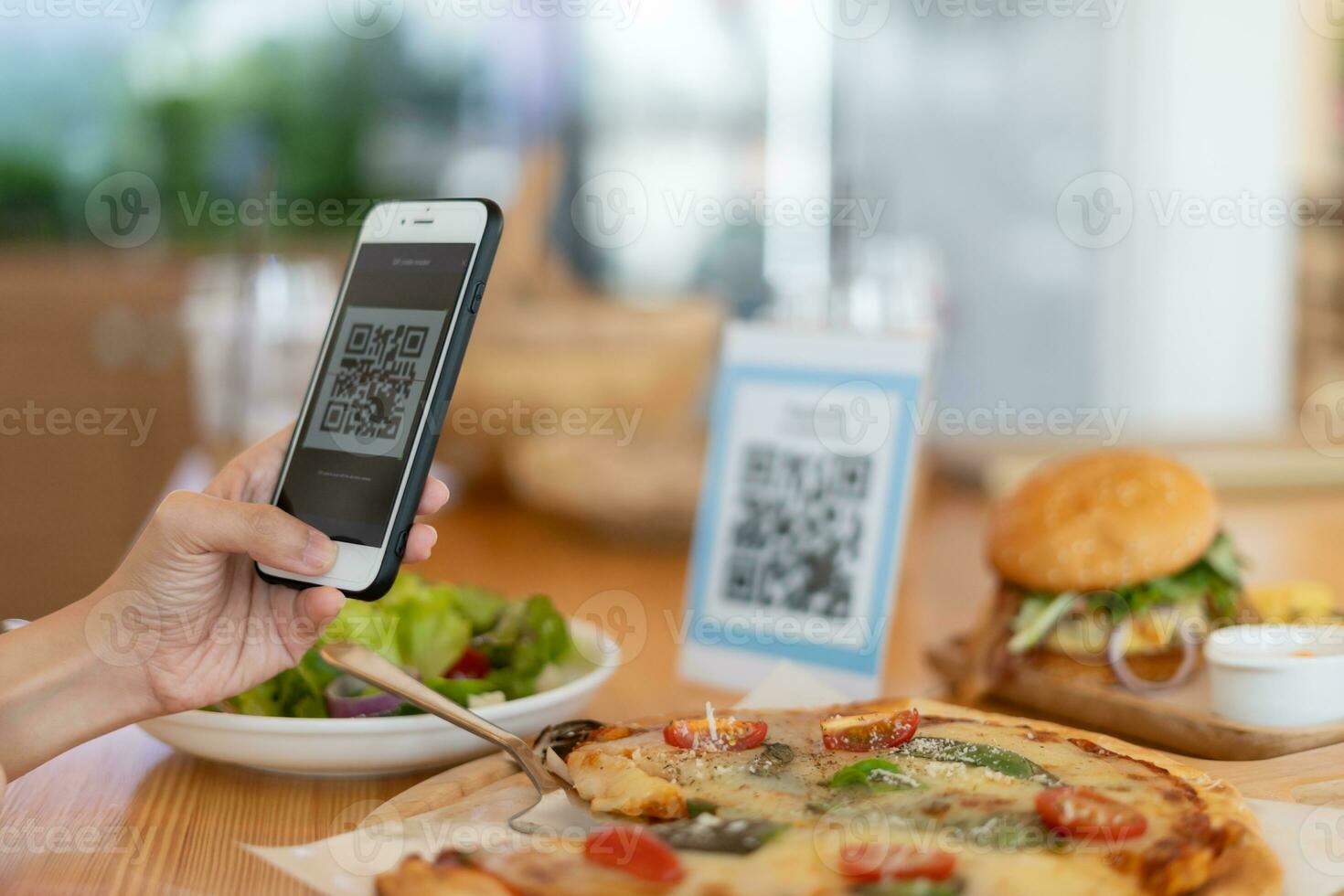 Woman use smartphone to scan QR code to pay in cafe restaurant with a digital payment without cash. Choose menu and order accumulate discount. E wallet, technology, pay online, credit card, bank app. photo