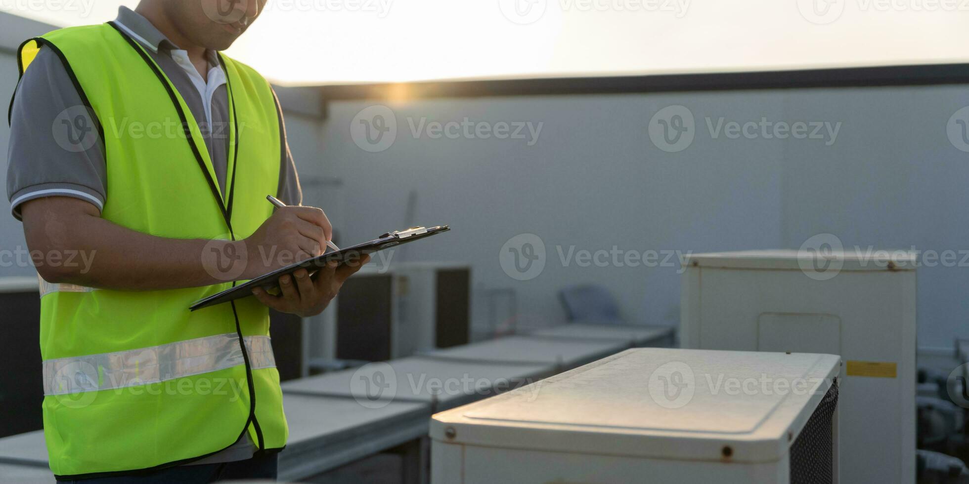 Asian maintenance engineer works on the roof of factory. contractor inspect compressor system and plans installation of air condition systems in construction. Checklist, inspector, control photo