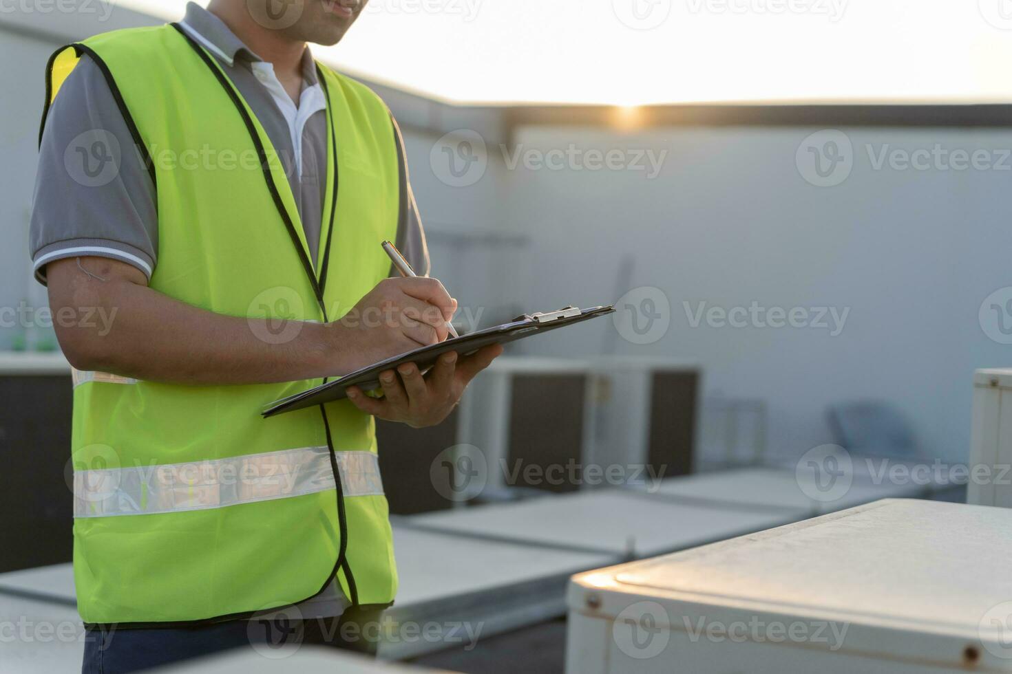 asiático mantenimiento ingeniero trabajos en el techo de fábrica. contratista inspeccionar compresor sistema y planes instalación de aire condición sistemas en construcción. Lista de Verificación, inspector, controlar foto