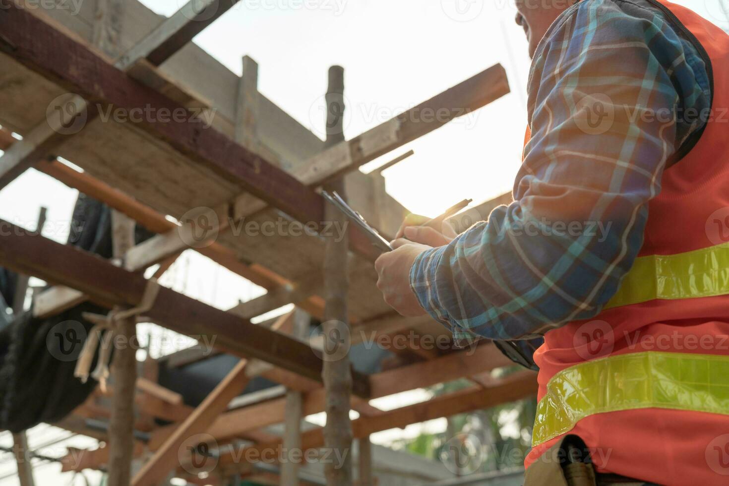 el inspector o ingeniero está inspeccionando la construcción y el aseguramiento de la calidad de la nueva casa usando una lista de verificación. ingenieros o arquitectos o contratistas trabajan para construir la casa antes de entregársela al propietario foto