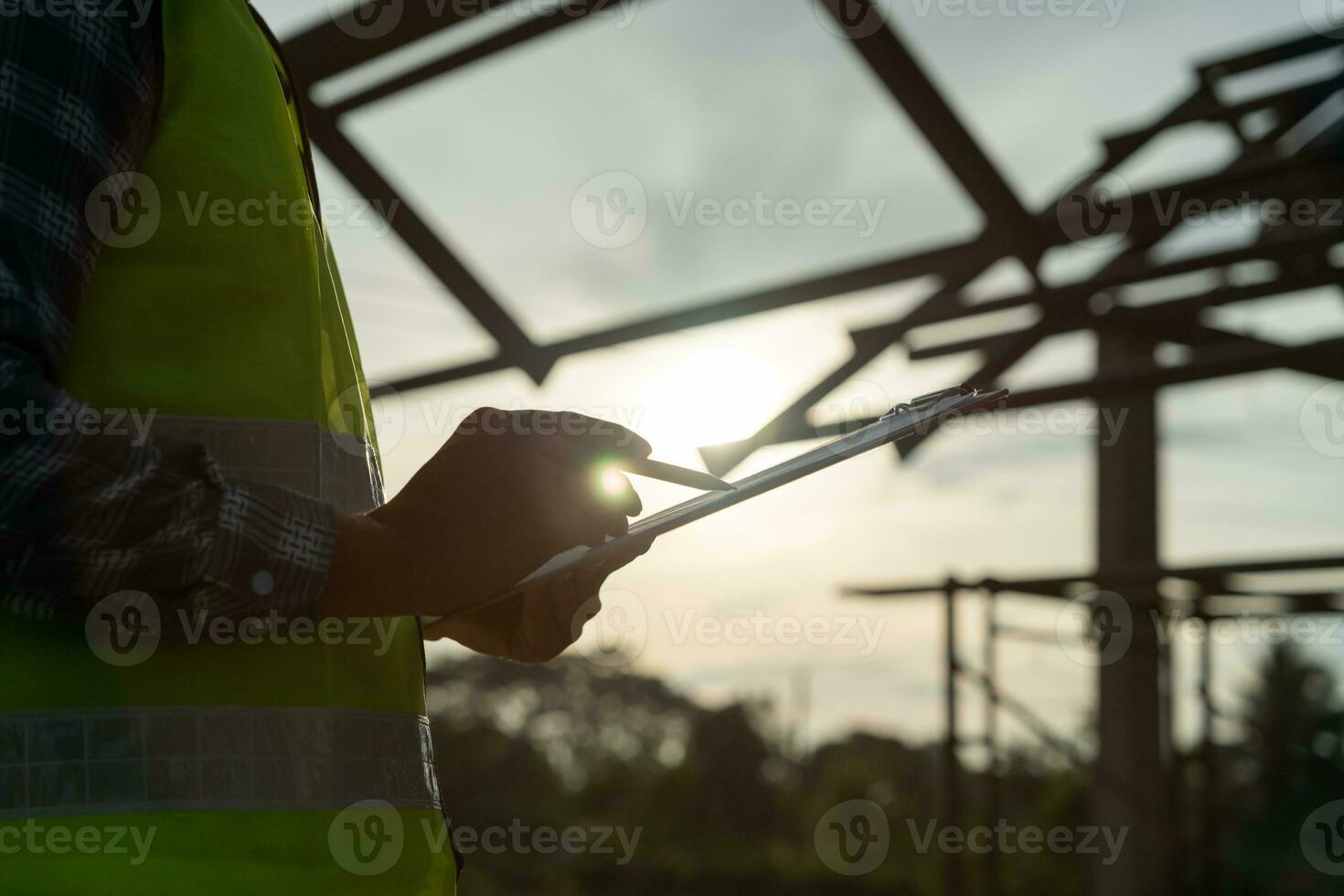 el inspector o ingeniero está inspeccionando la construcción y el aseguramiento de la calidad de la nueva casa usando una lista de verificación. ingenieros o arquitectos o contratistas trabajan para construir la casa antes de entregársela al propietario foto