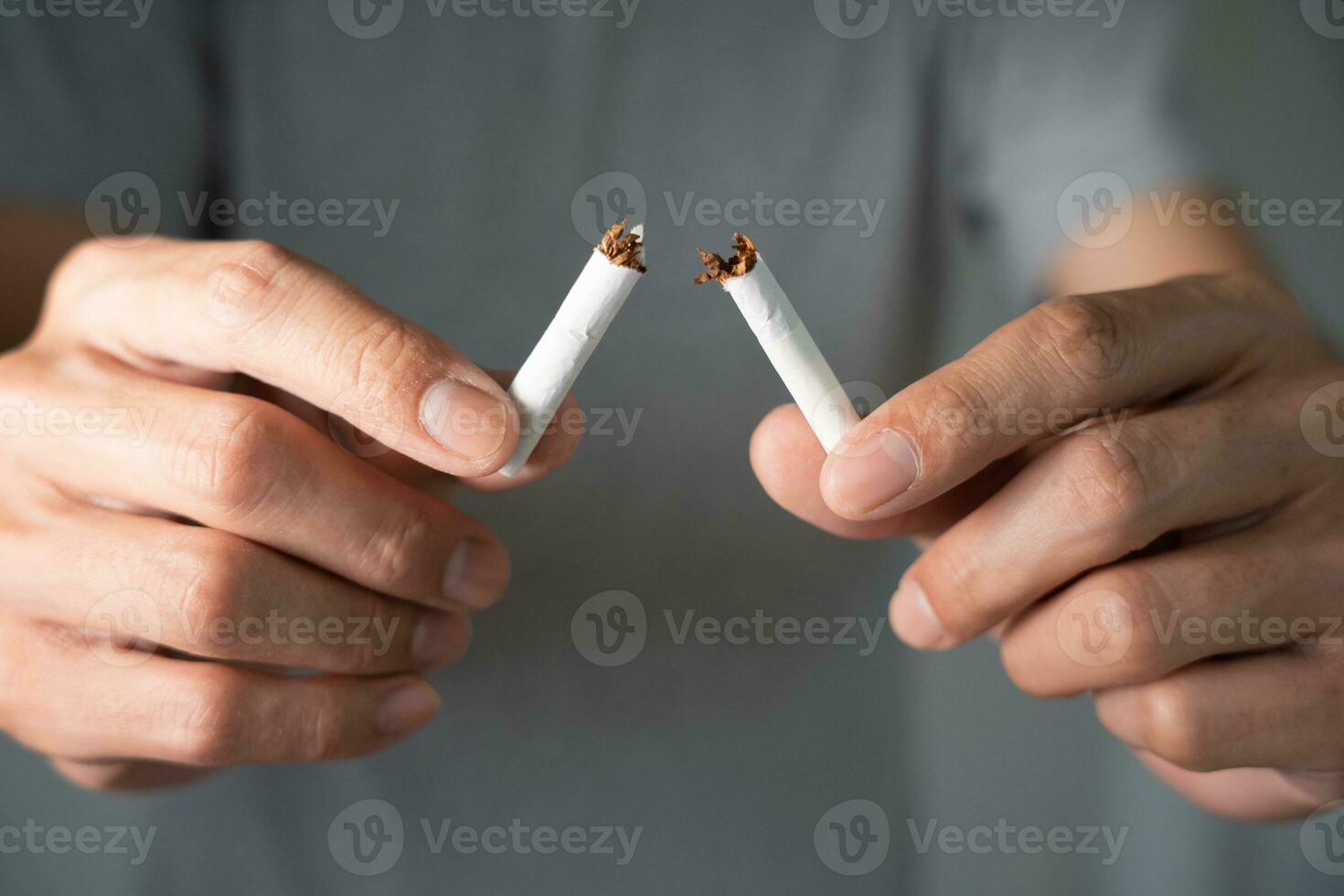 No Fumar. el hombre deja de fumar, se niega, rechaza, rompe el cigarrillo, dice que no. dejar de fumar por salud. día mundial del tabaco. drogas, cáncer de pulmón, enfisema, enfermedad pulmonar, narcótico, efecto nicotina foto