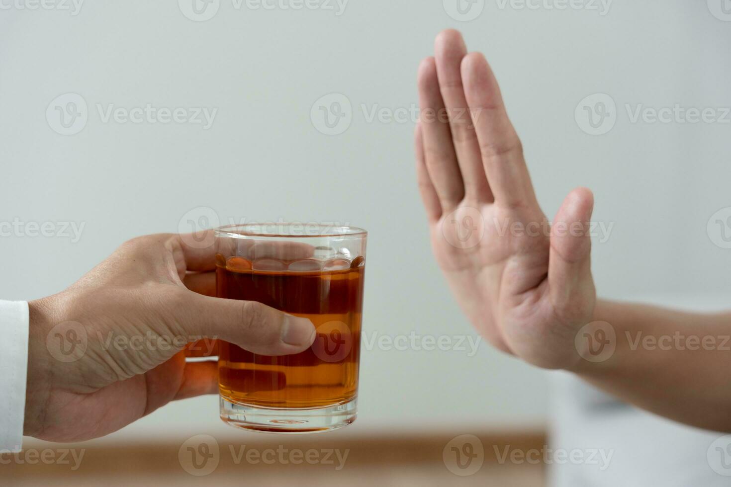 man refuses say no and avoid to drink an alcohol whiskey , stopping hand sign male, alcoholism treatment, alcohol addiction, quit booze, Stop Drinking Alcohol. Refuse Glass liquor, unhealthy, reject photo