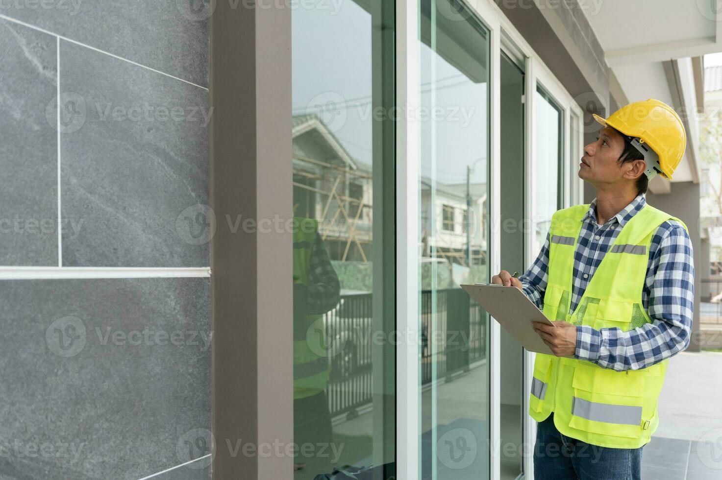 el inspector o ingeniero está inspeccionando la construcción y el aseguramiento de la calidad de la nueva casa usando una lista de verificación. ingenieros o arquitectos o contratistas trabajan para construir la casa antes de entregársela al propietario foto