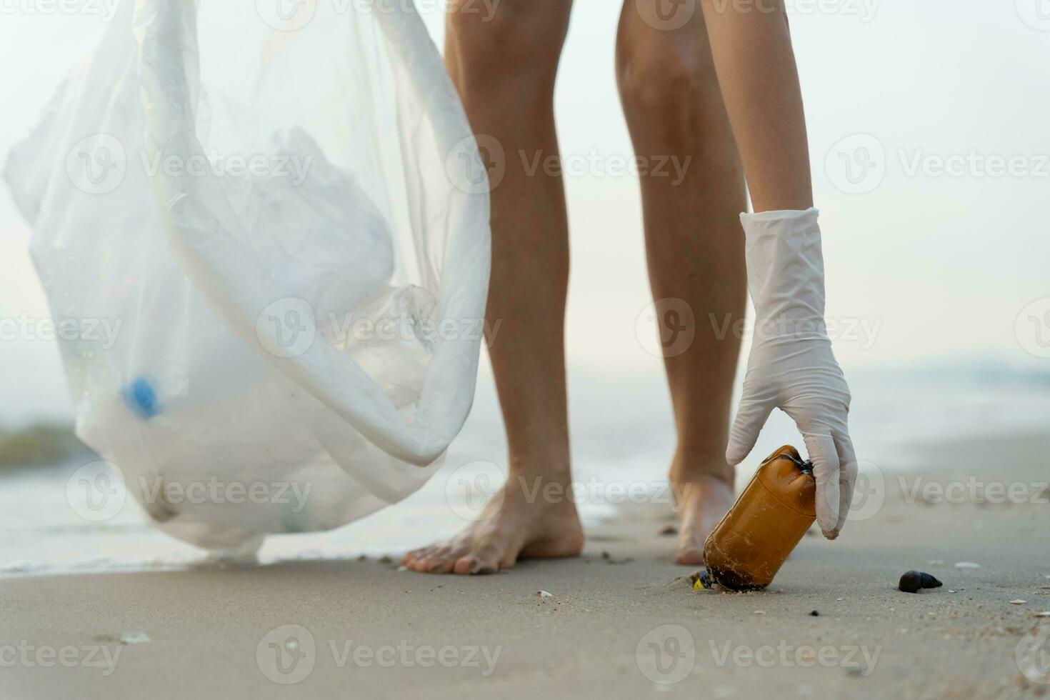 Save water. Volunteer pick up trash garbage at the beach and plastic bottles are difficult decompose prevent harm aquatic life. Earth, Environment, Greening planet, reduce global warming, Save world photo