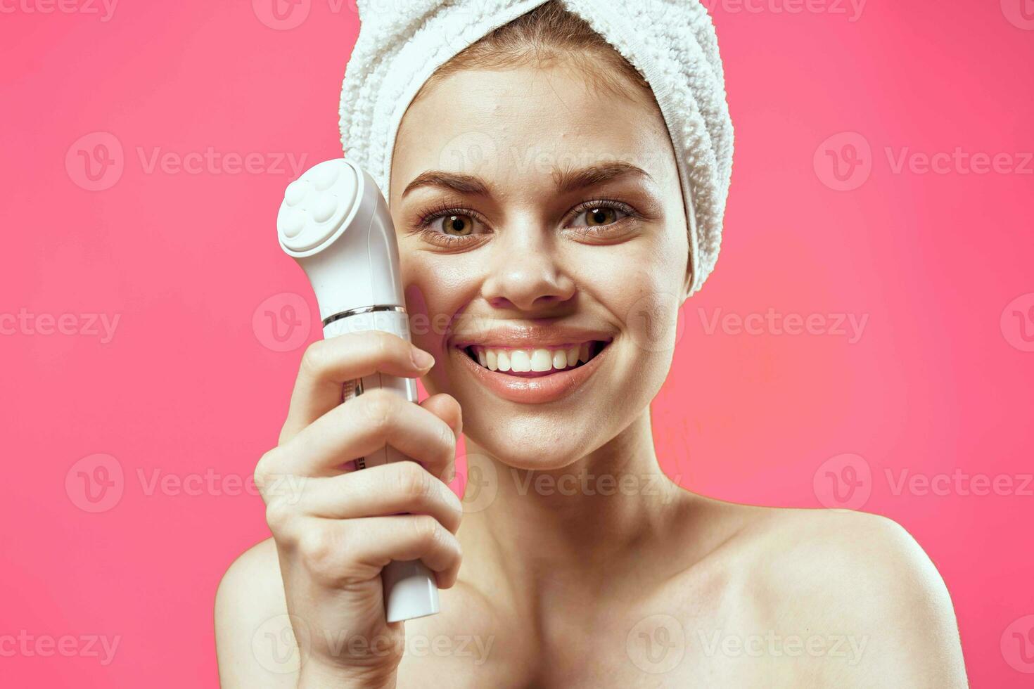 cheerful woman with bare shoulders facial cleansing photo