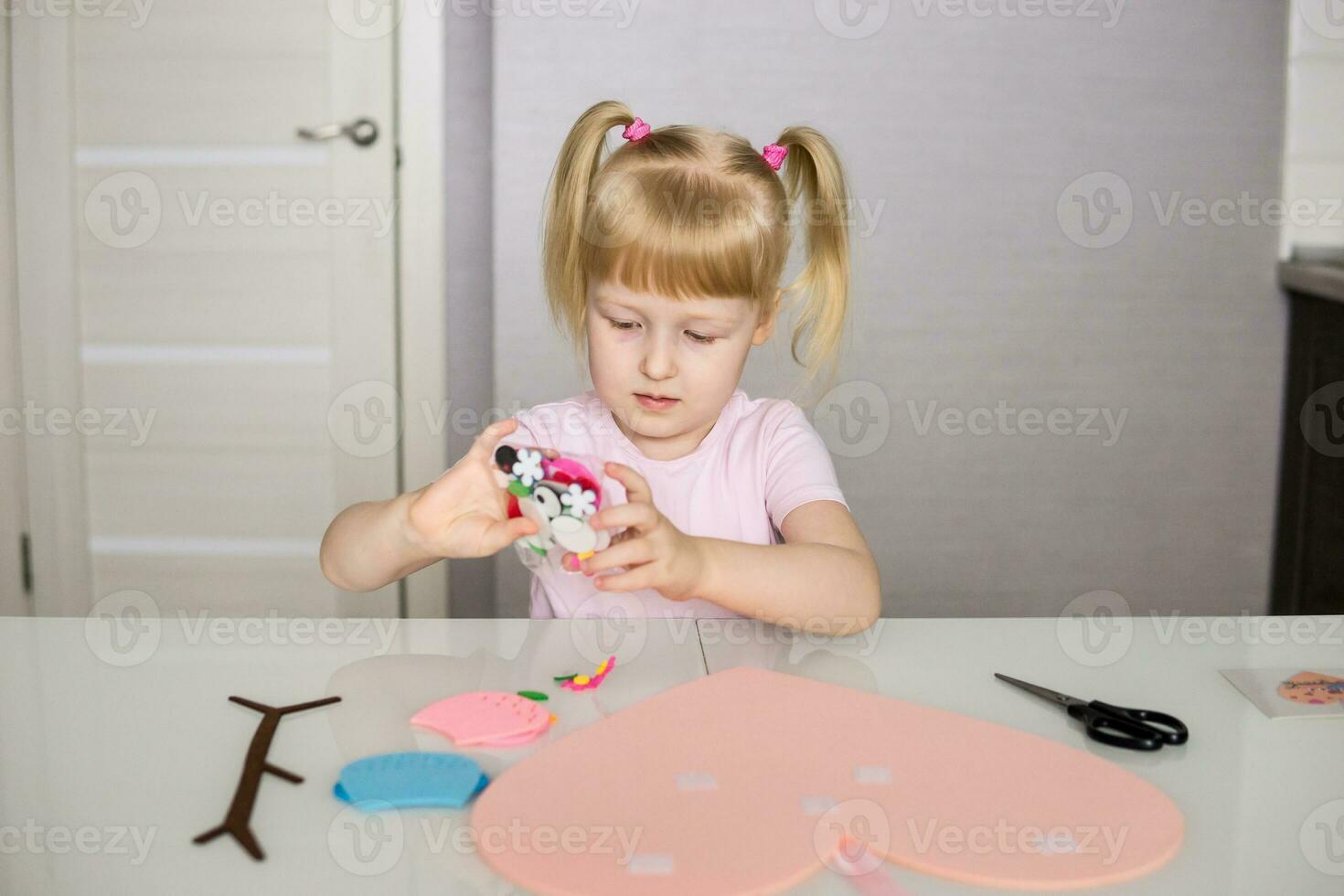 un blogger niña hace un sintió arte para San Valentín día en el forma de un corazón. el concepto de para niños creatividad y hecho a mano. foto