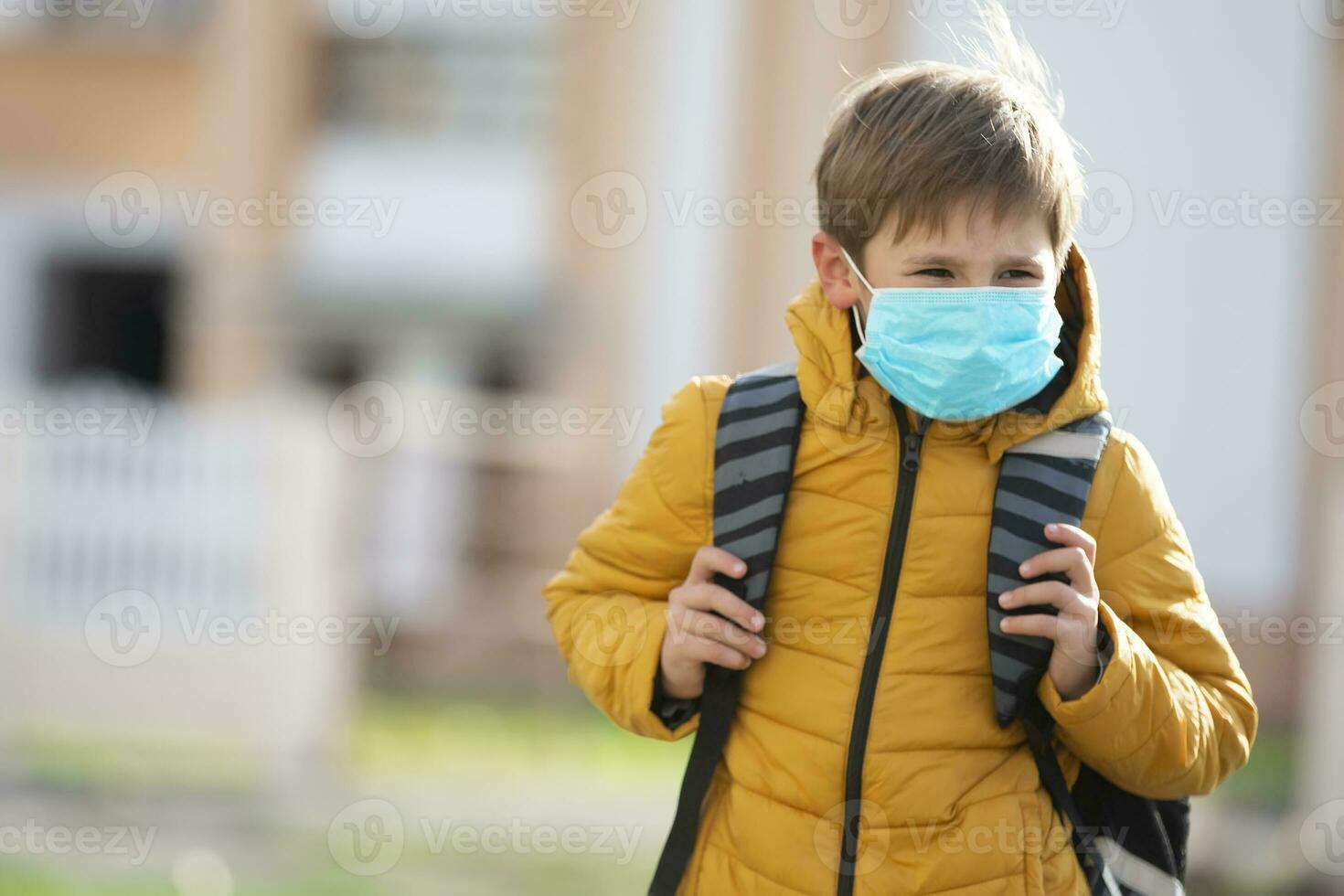 A masked child goes to school after being quarantined and isolated from the coronavirus. photo