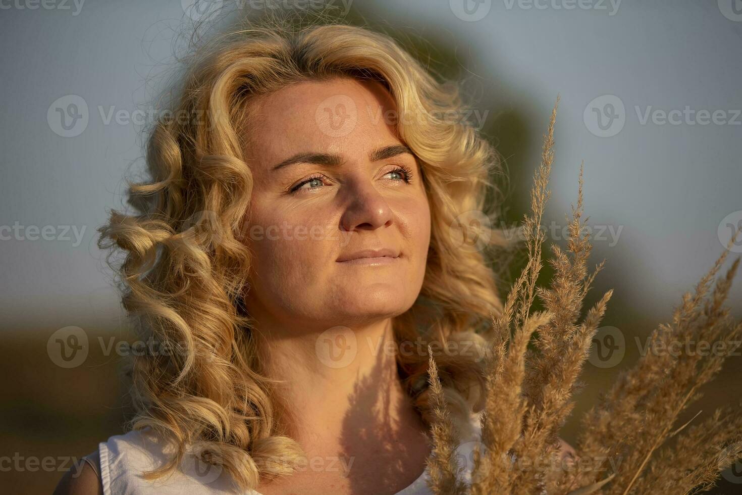 Beautiful middle-aged woman on the background of the field. photo