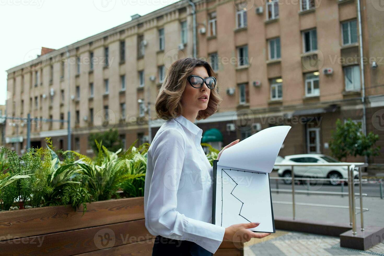 woman manager in white shirt outdoors with documents photo