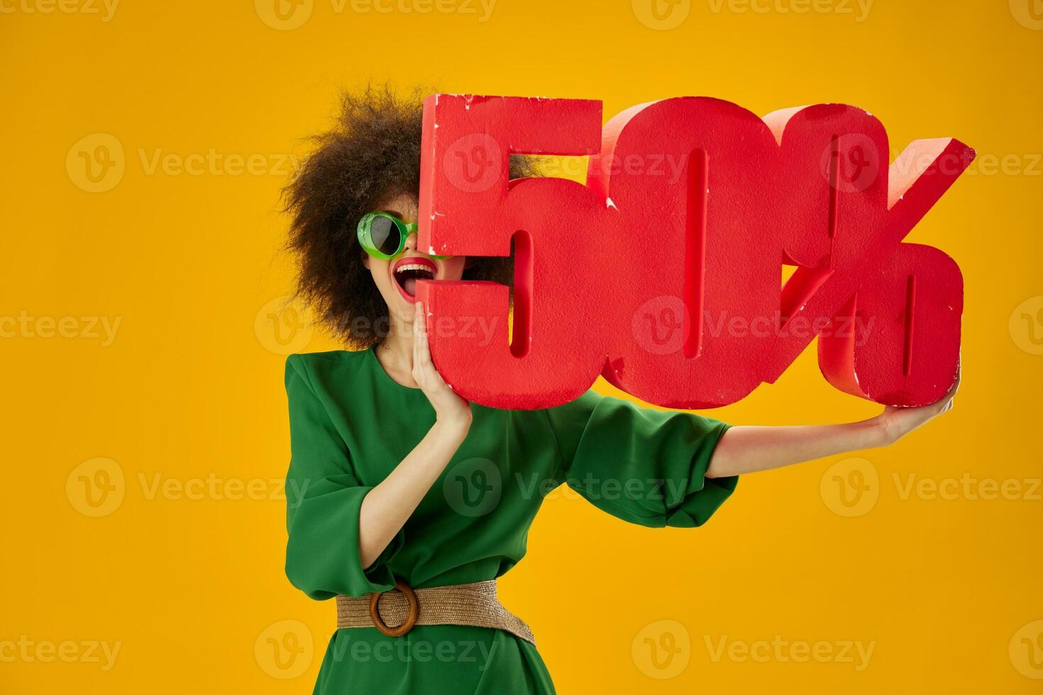 Portrait of a charming lady curly hairstyles green dress fifty percent discount yellow background unaltered photo