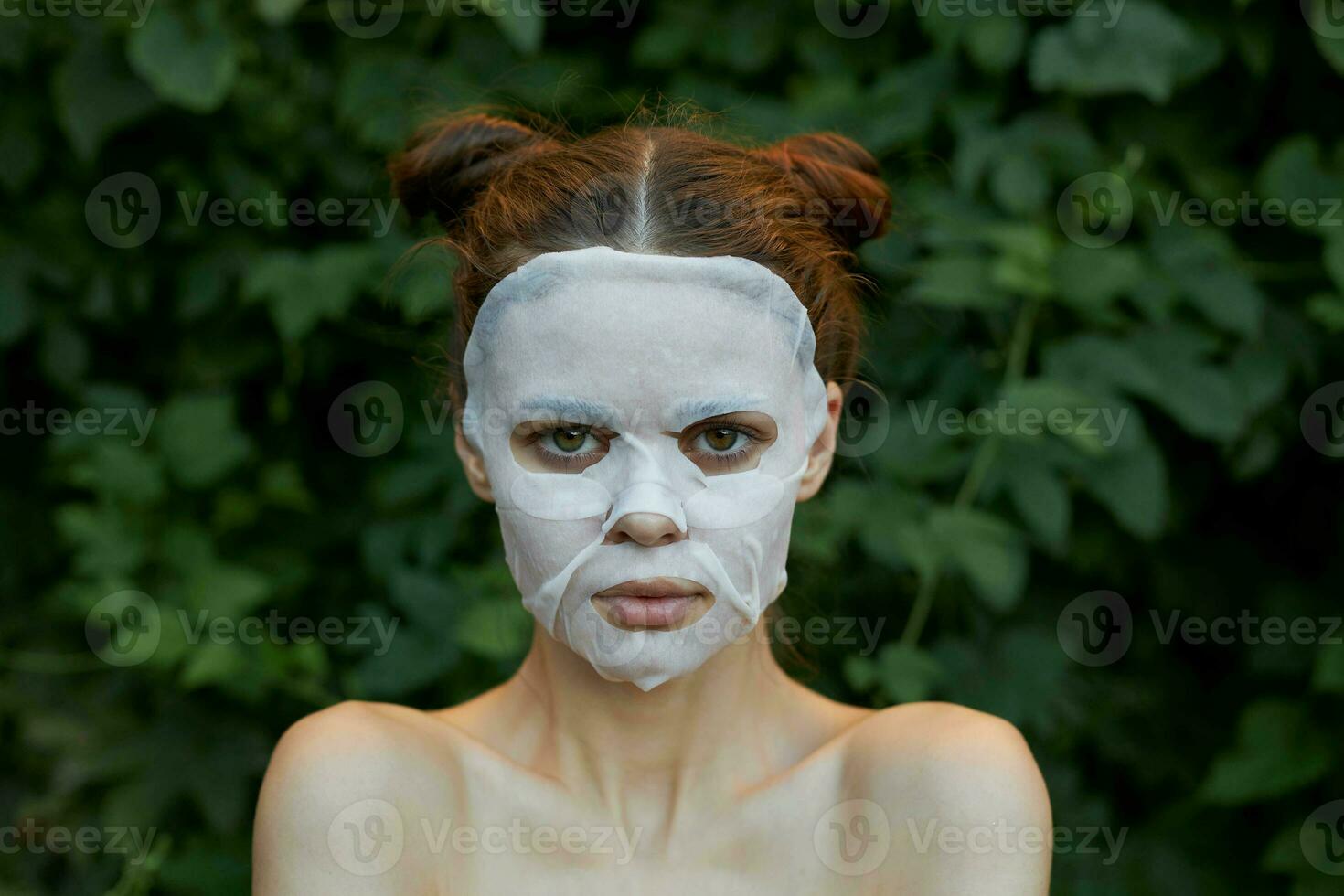 Nice woman face mask Front view clean skin cosmetology bushes in the background photo