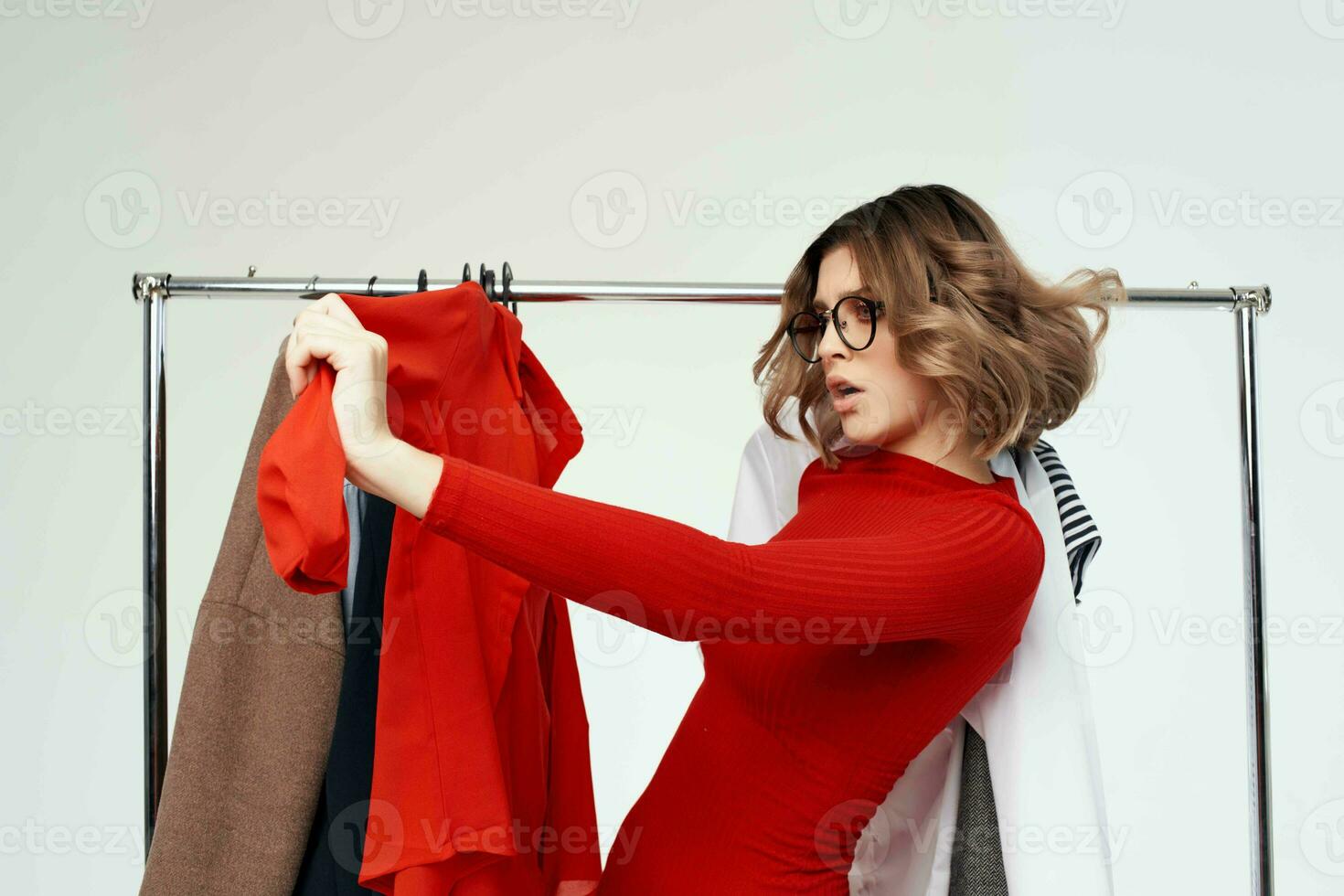 alegre mujer con lentes molesto en ropa tienda adicto a las compras emociones foto