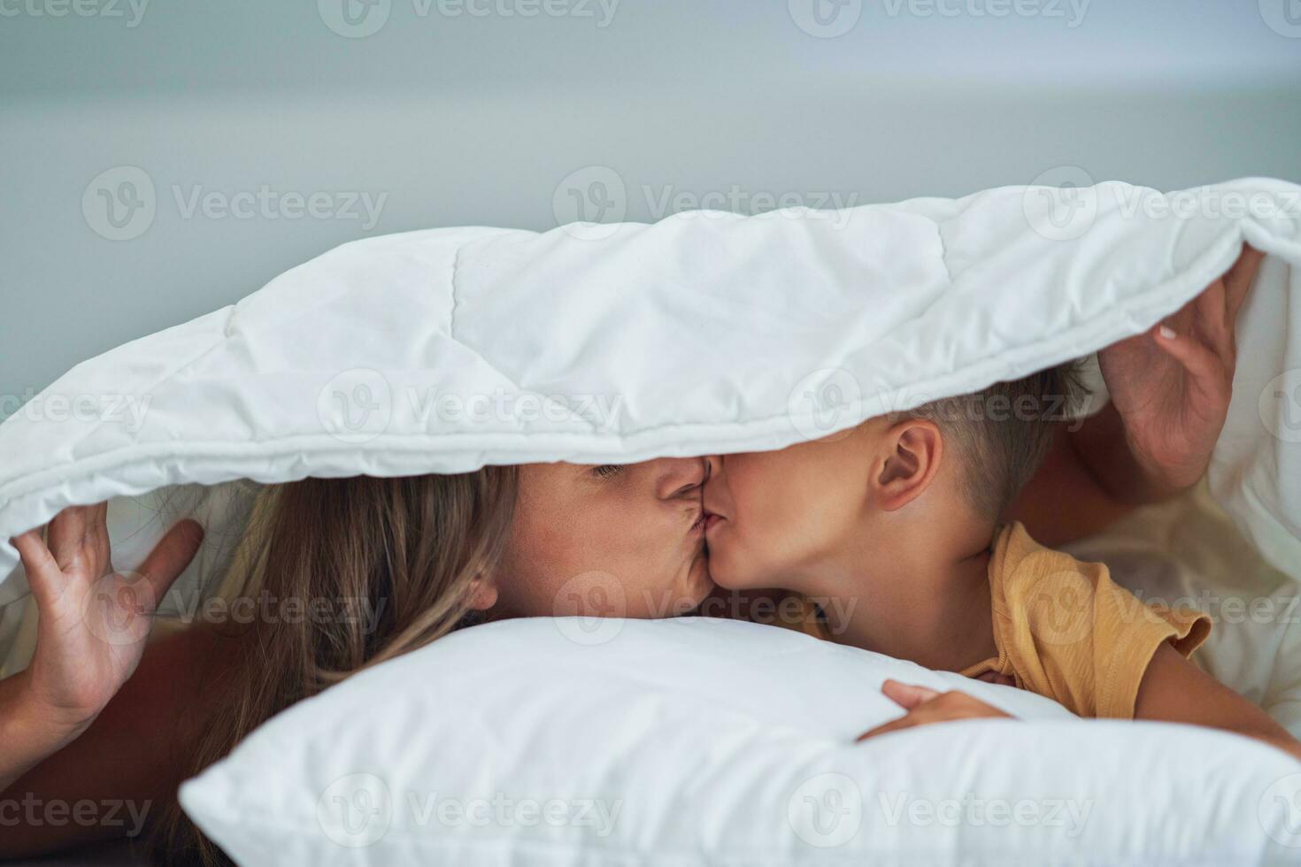 joven madre con 4 4 años antiguo hijo en cama foto