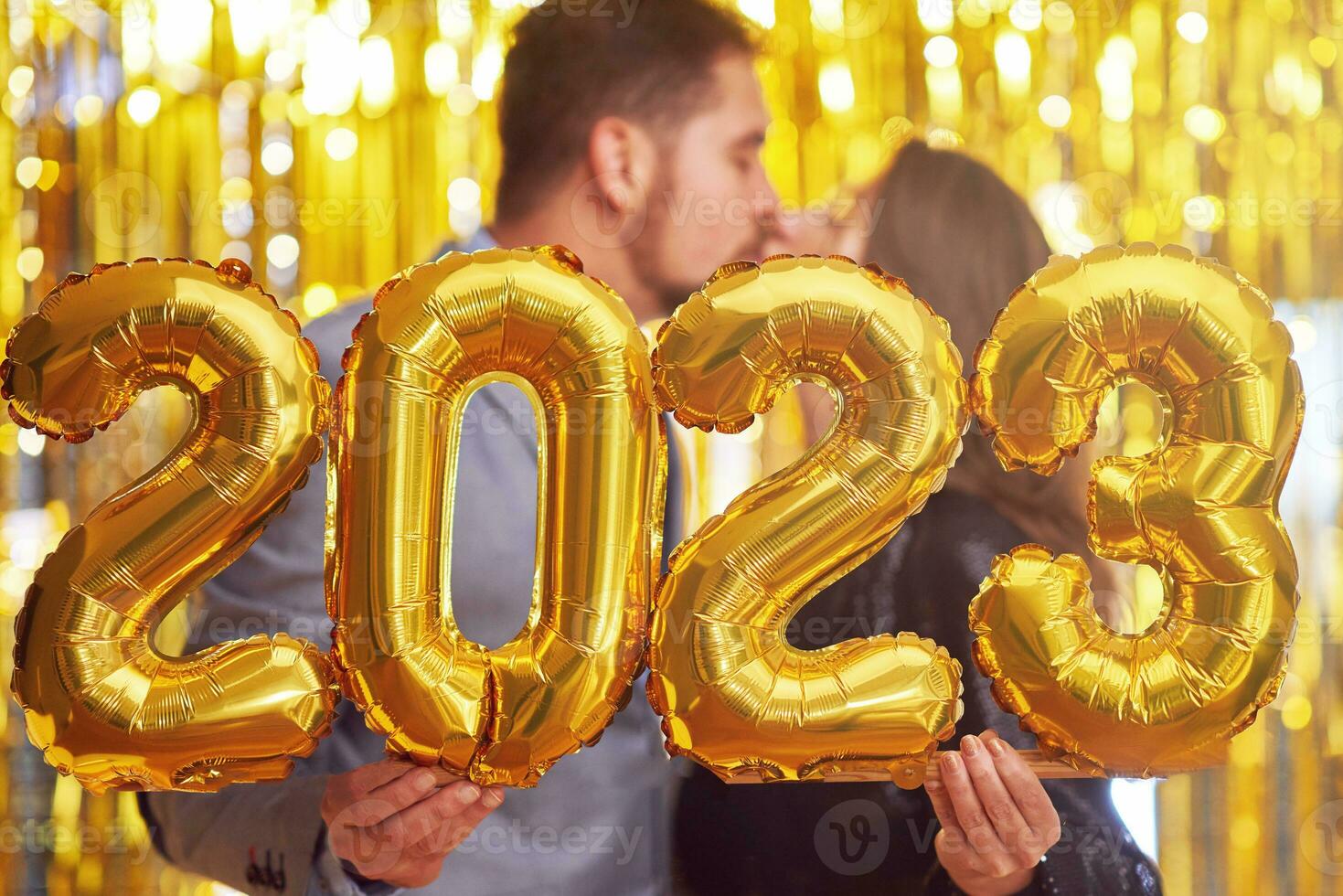 Couple at new year eve party with gold balloons photo