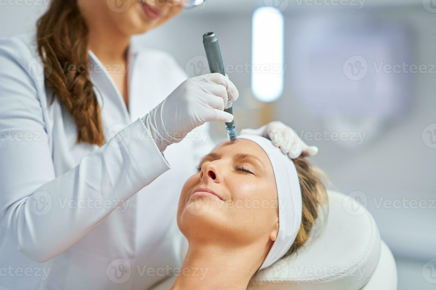 Woman in a beauty salon having needle mesotherapy treatment photo