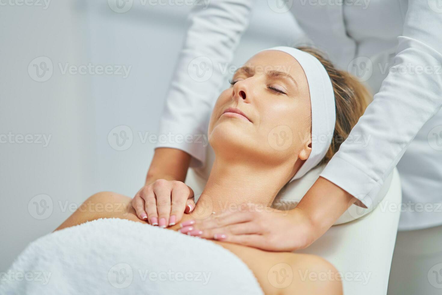 Young nice woman having face massage in spa photo