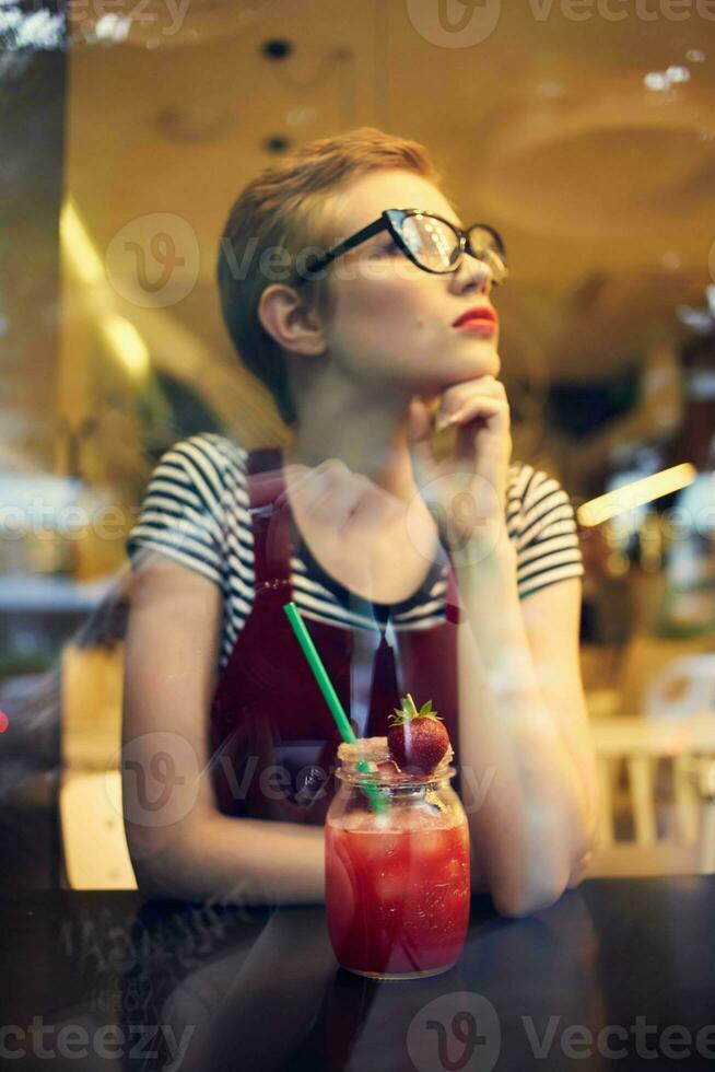 woman with short hairstyle in a cafe cocktail rest pensive look photo