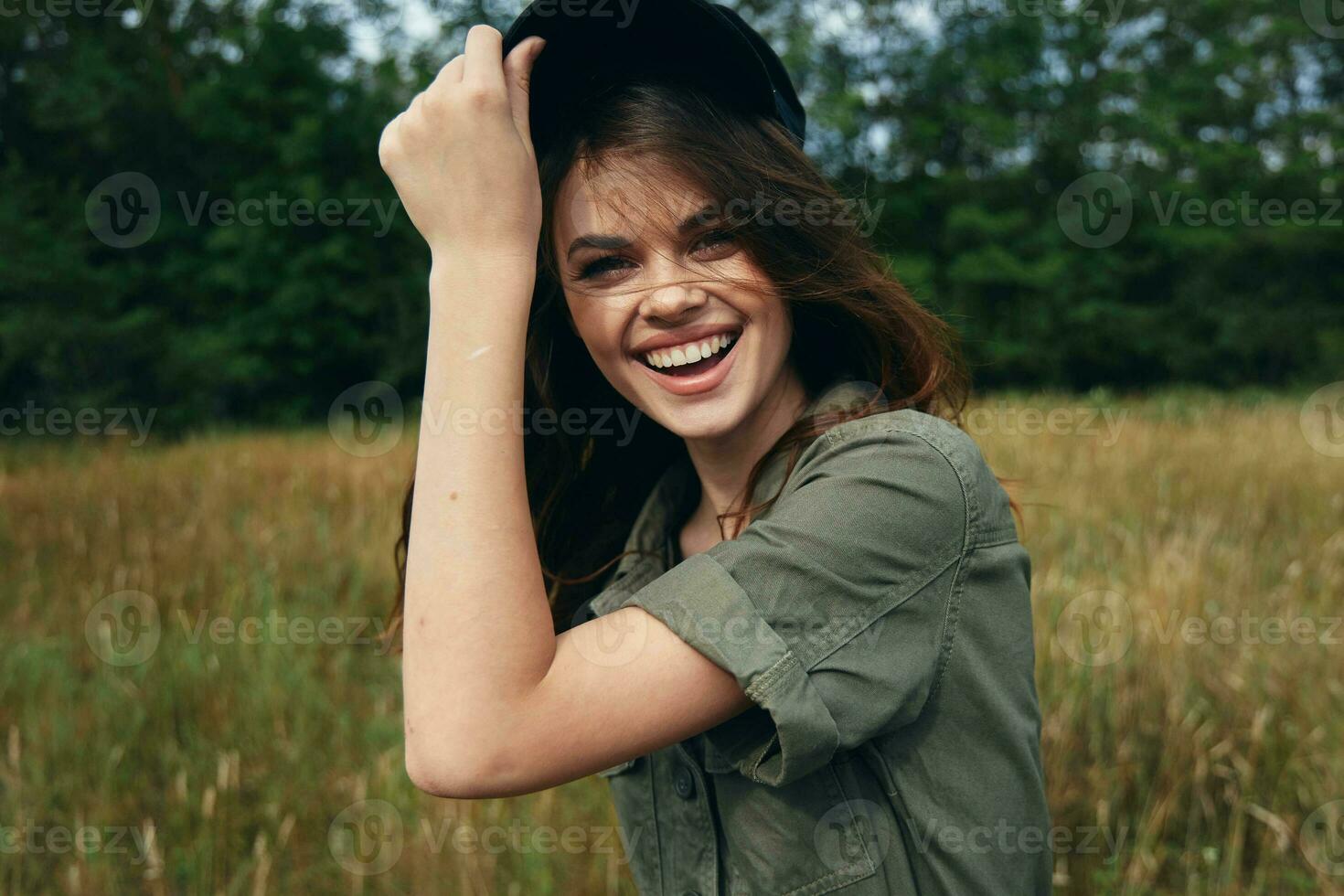 Happy woman in blue cap and green shirt laughs photo