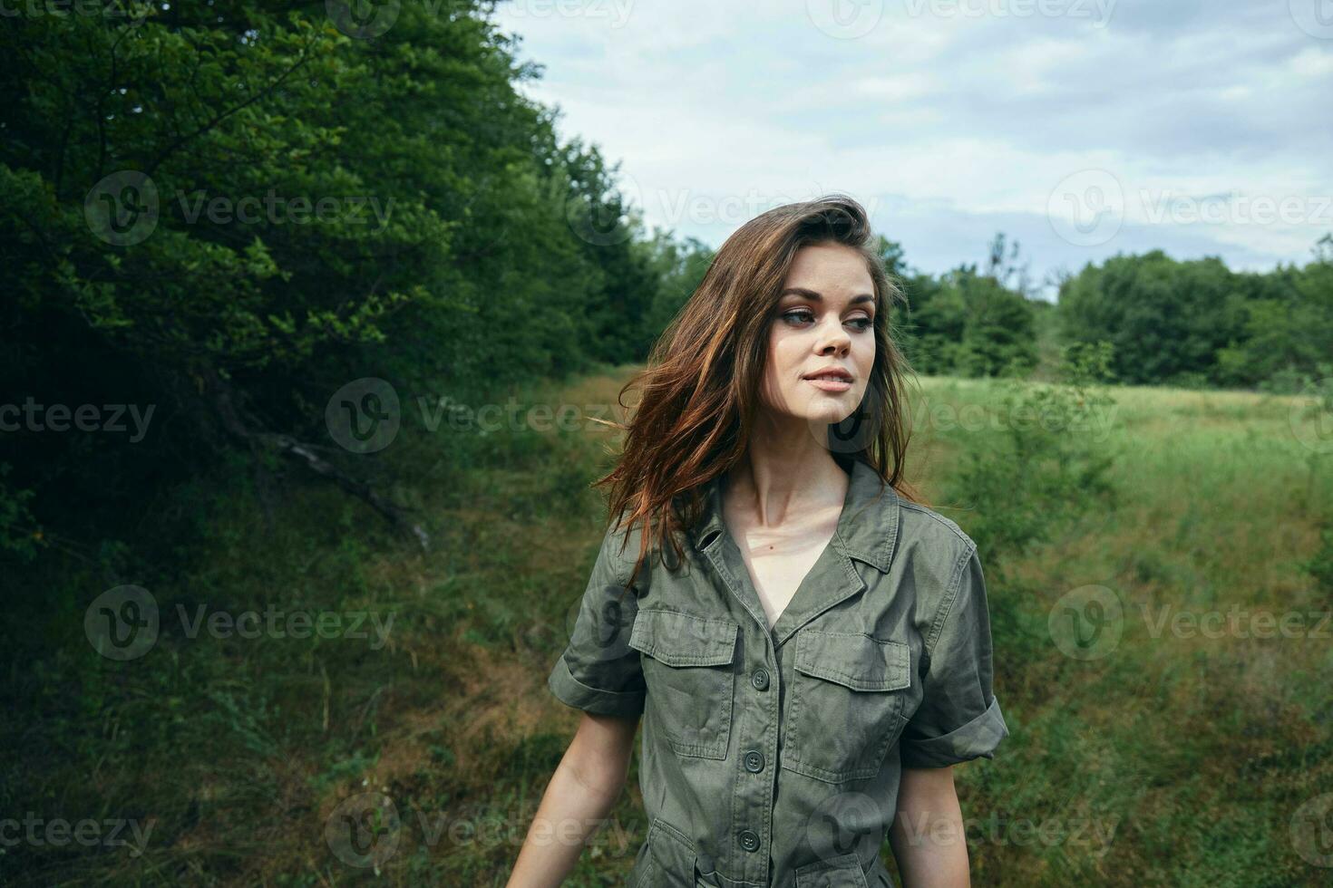 Woman in green jumpsuit looking to the side cropped view fresh air landscape nature photo