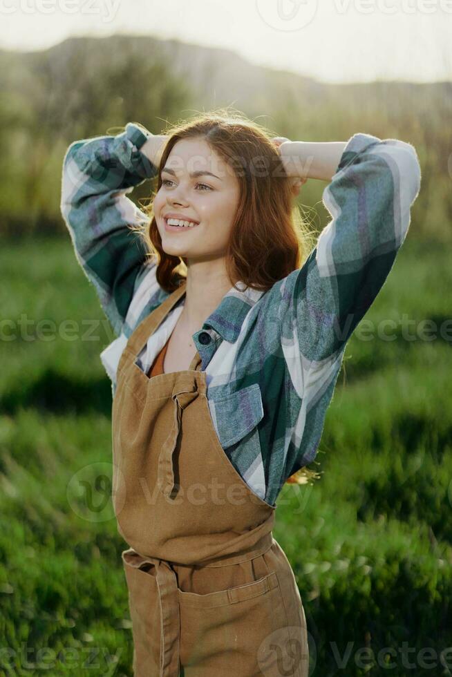 Portrait of a young girl on a summer day in the rays of the setting sun with a beautiful smile, dressed as a farmer and gardener photo