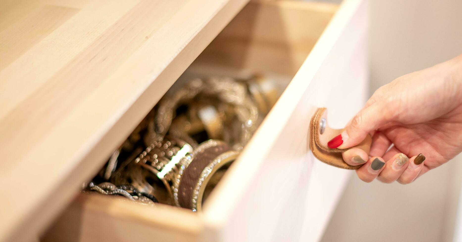 Female hand opening wood drawer with leather handle for arrange accessories in the room. photo