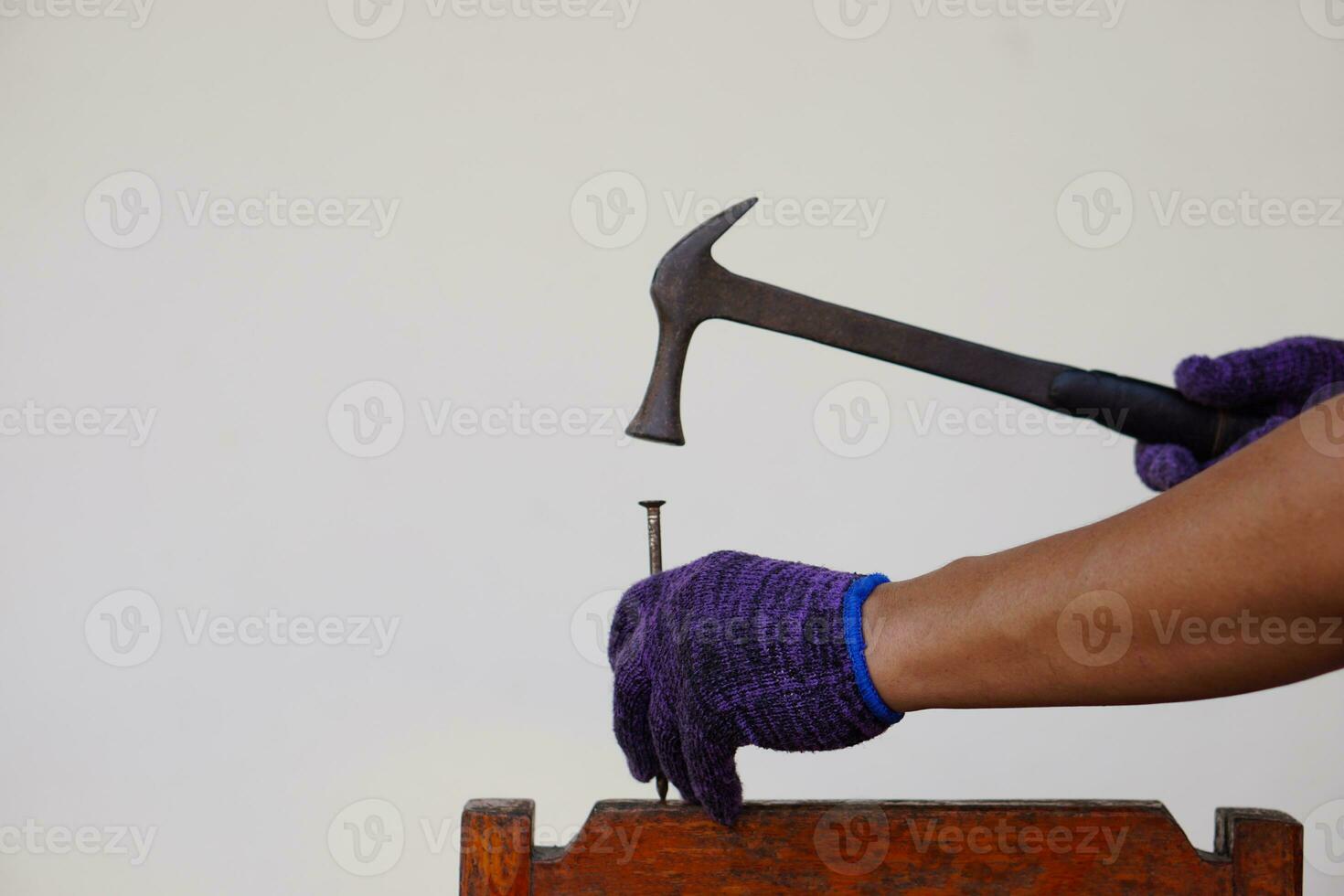 la mano del carpintero de primer plano usa un martillo para golpear el clavo. concepto, herramientas de carpintería y construcción. reparación o arreglo, carpintería bricolaje. foto