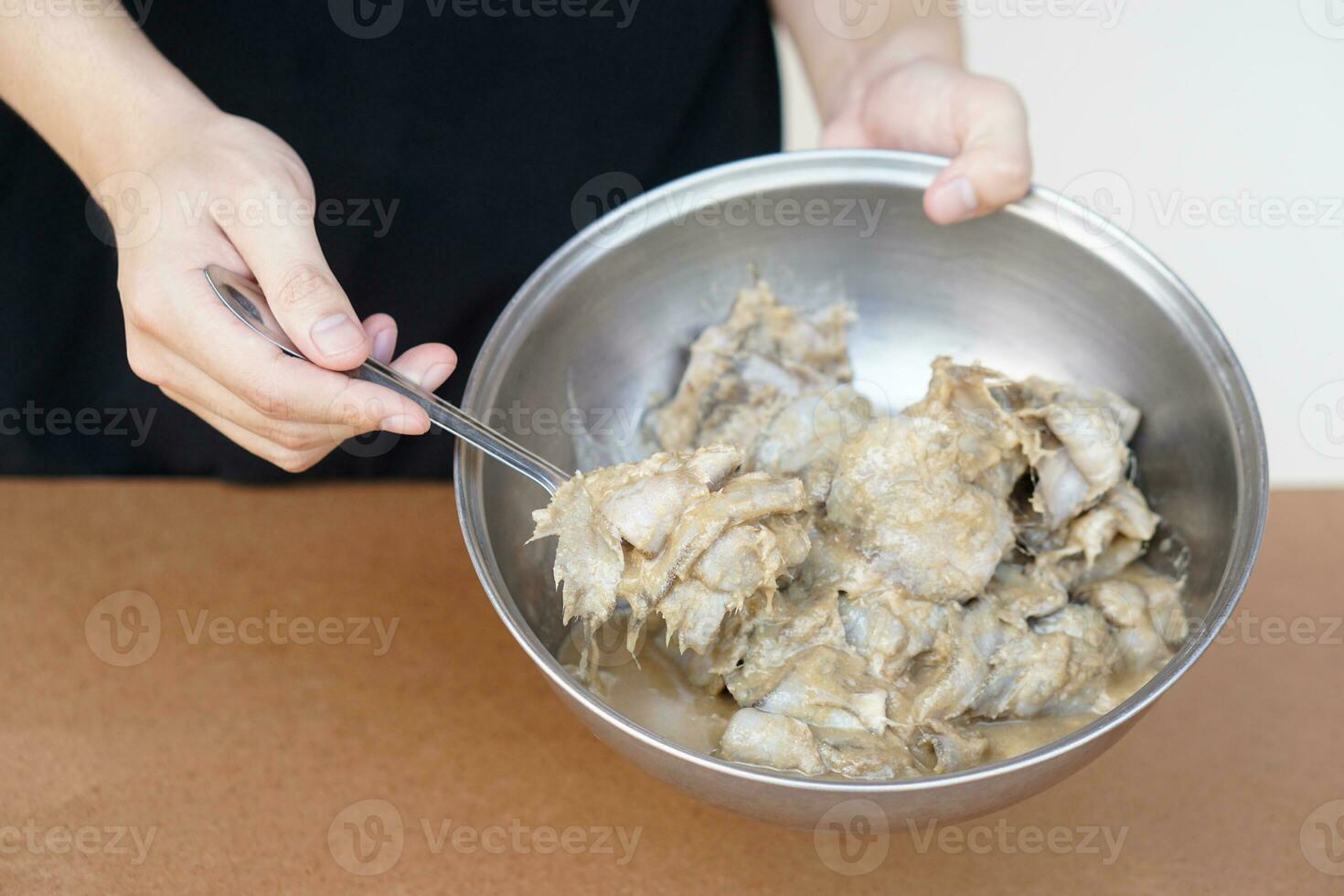 Hands show bowl of pickled fish or fermented fish or Pla ra in Thai name, traditional Thai food. Concept, food preservation. Food ingredient that can be cooked in many menu. photo