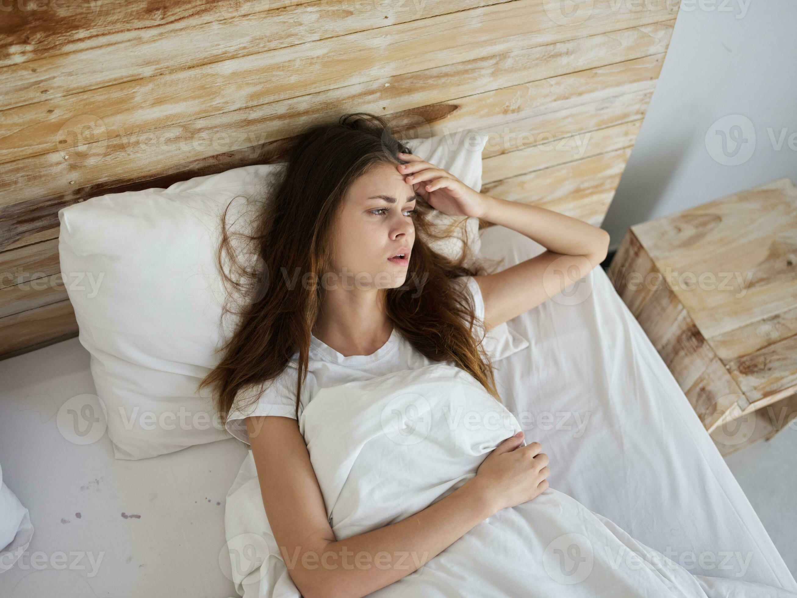 crying woman lying in bed dissatisfaction health problems 23415873
