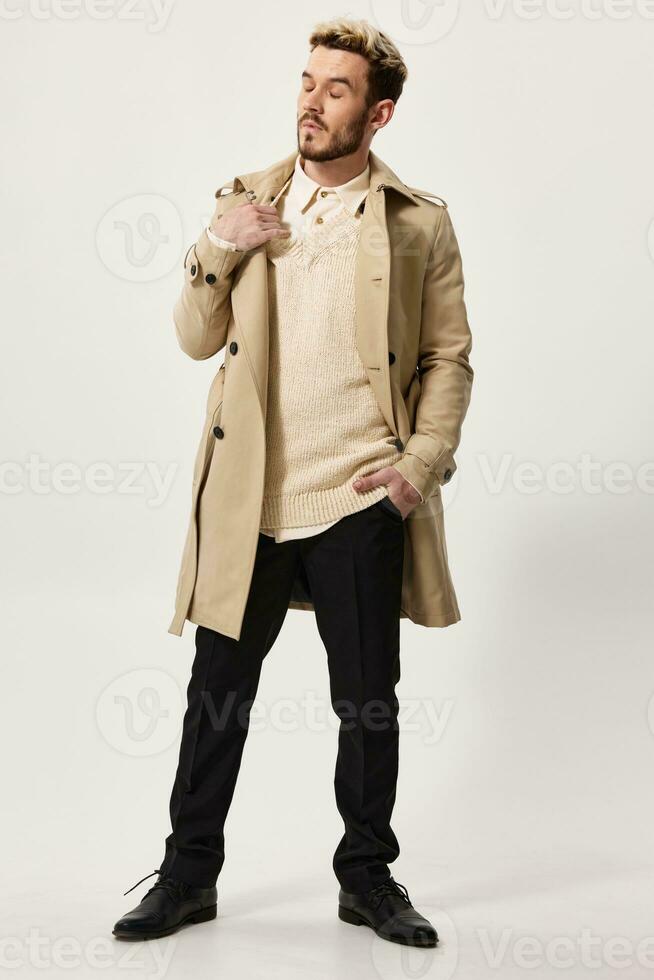 a man in a first coat and a sweater, do not touch his shoulder and look to the side hand in his pocket photo