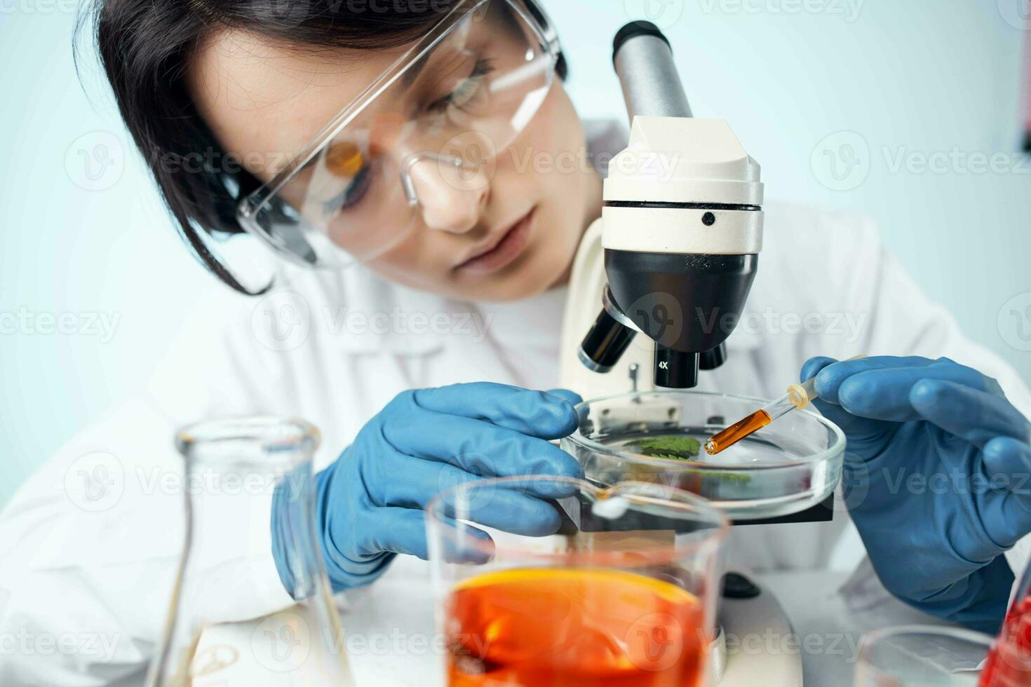 mujer en laboratorio ajusta microscopio investigación análisis tecnología foto