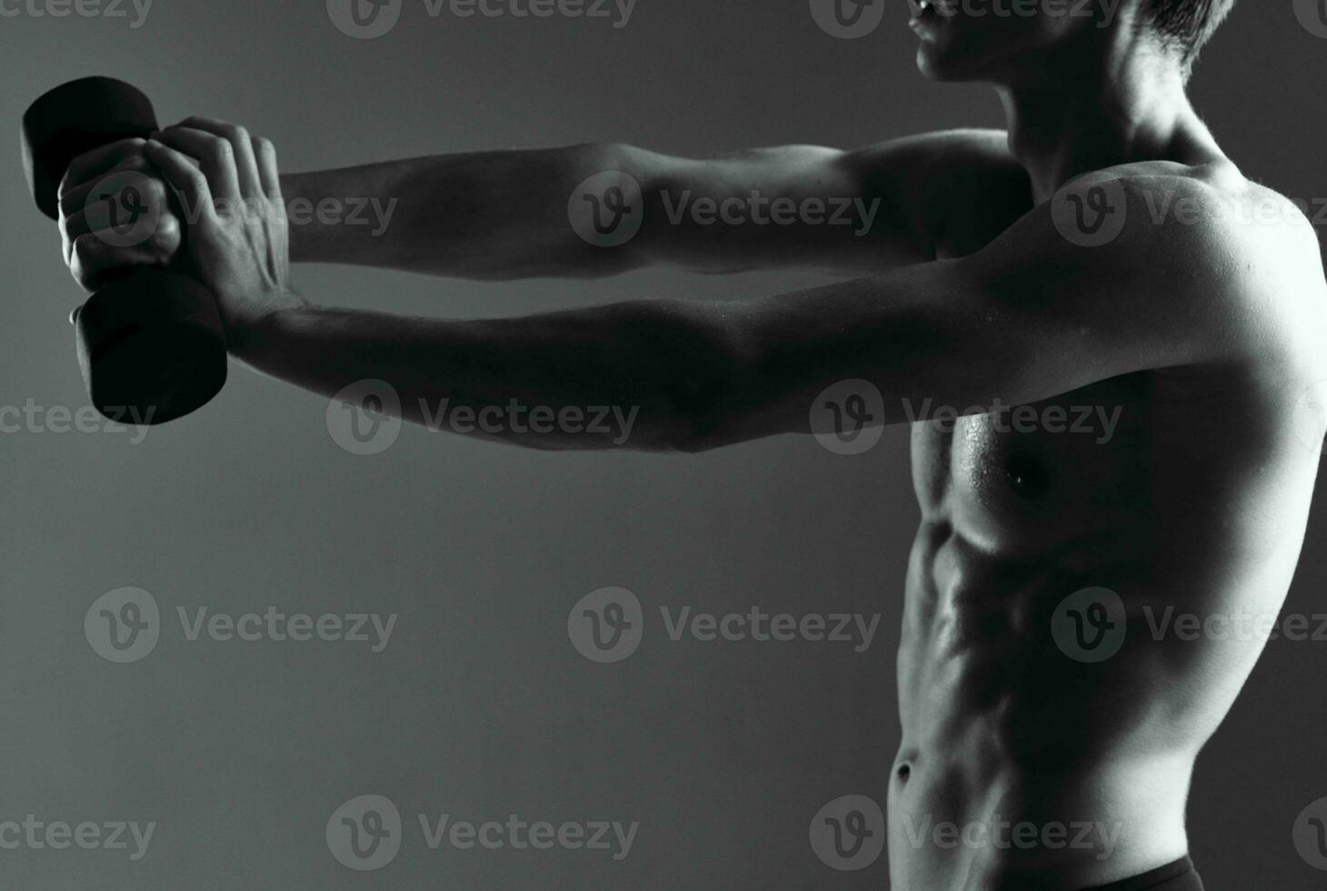 athletic man with dumbbells in hand doing exercises photo