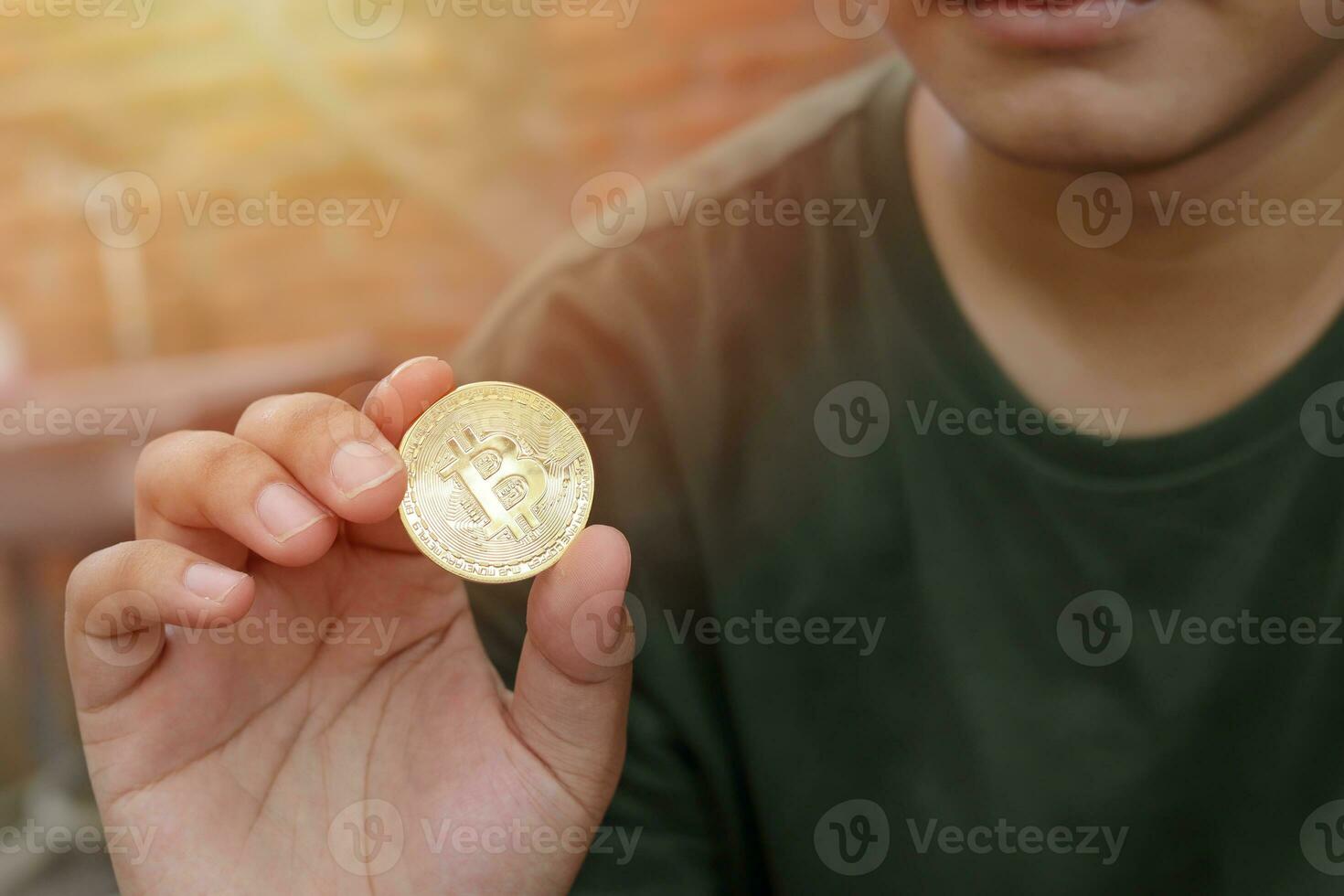 Close up of bitcoin is held by man with blur background. Cryptocurrency trading concept. Selective focus image photo