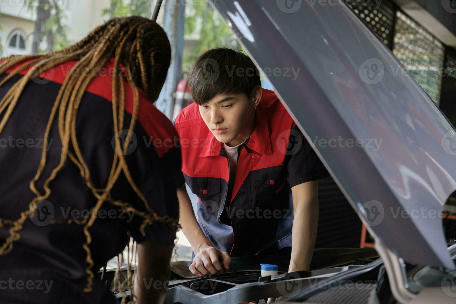 Two professional automotive mechanical partners check and repair an EV car battery and hybrid engine at a maintenance garage, expert electric vehicle service, and fixing occupations auto industry. photo