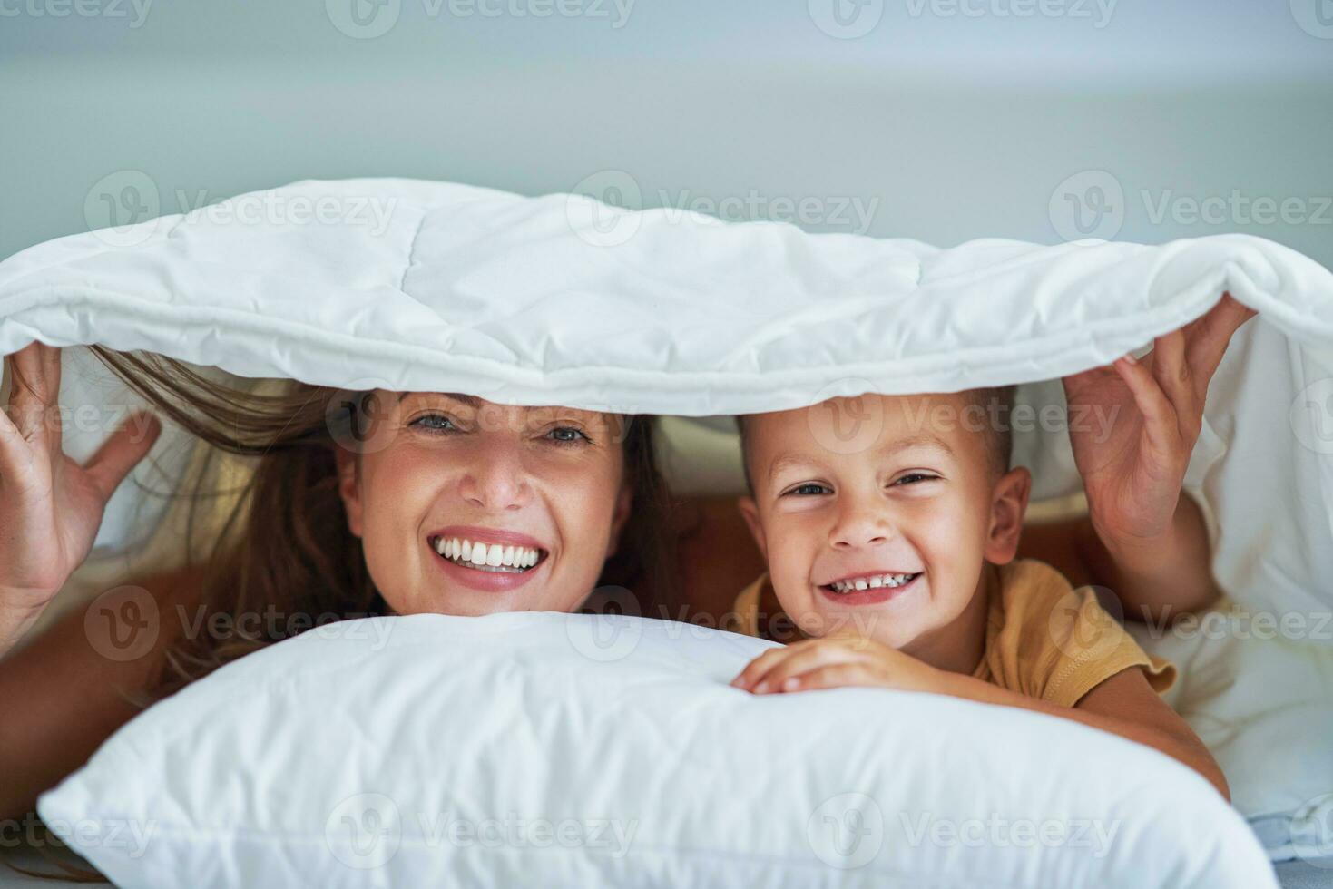 Young mother with 4 years old son in bed 23417332 Stock Photo at Vecteezy