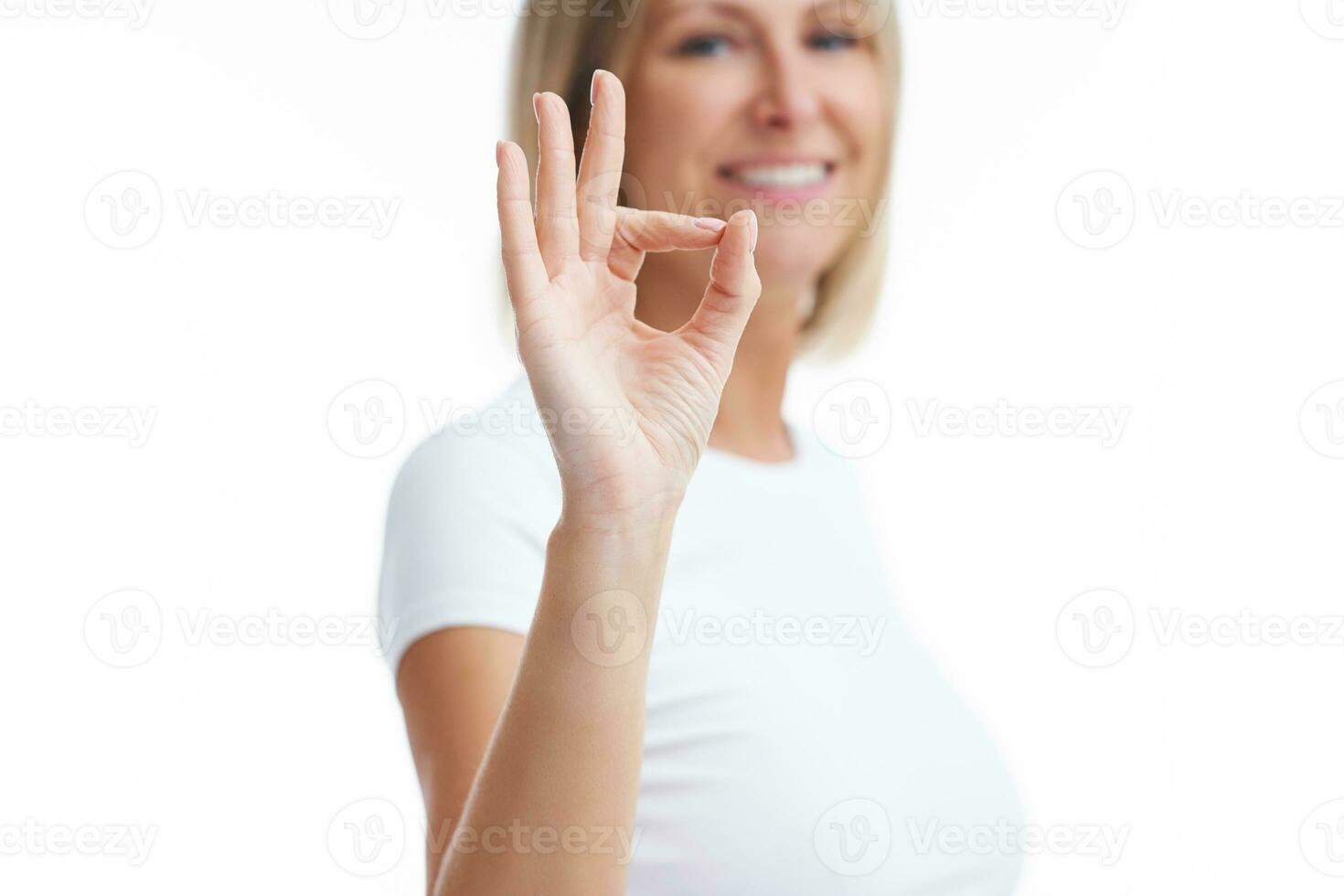 Picture of blonde woman over back isolated background showing ok photo