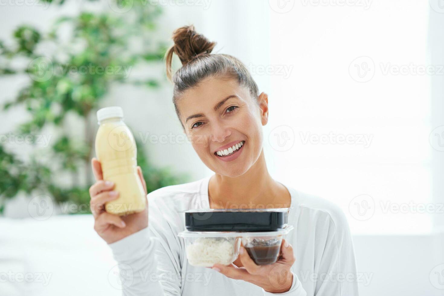 Young woman on bed with food catering box photo