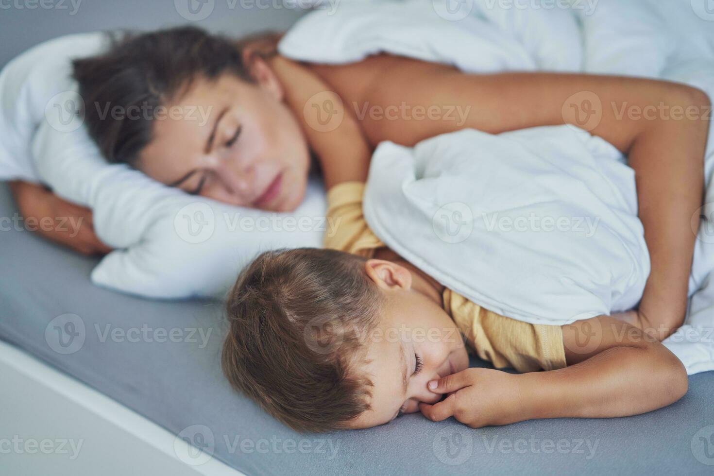 Young mother with 4 years old son in bed 23417375 Stock Photo at Vecteezy